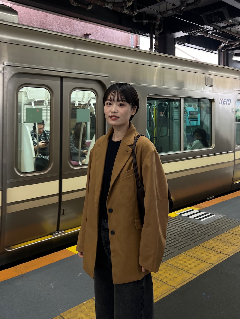 ブラック系のデニムパンツ、ブラウン系のテーラードジャケットを着用したレディースの秋コーディネートの2枚目の写真