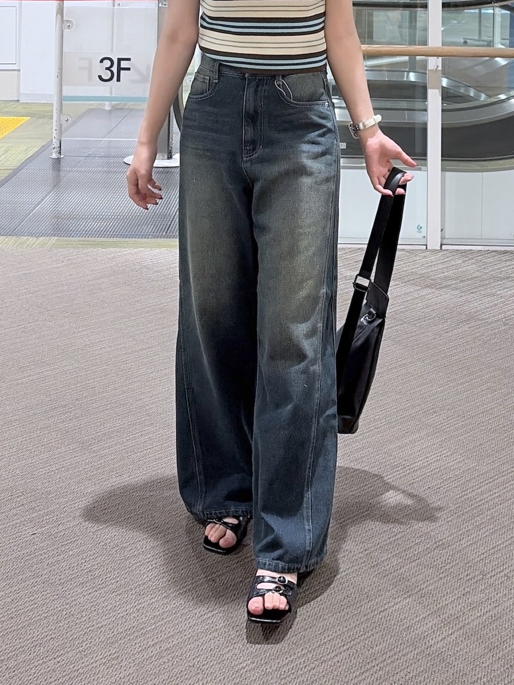 ブラウン系のTシャツ/カットソー、ブルー系のニット/セーター、ブラック系のショルダーバッグを着用したレディースの夏コーディネートの3枚目の写真