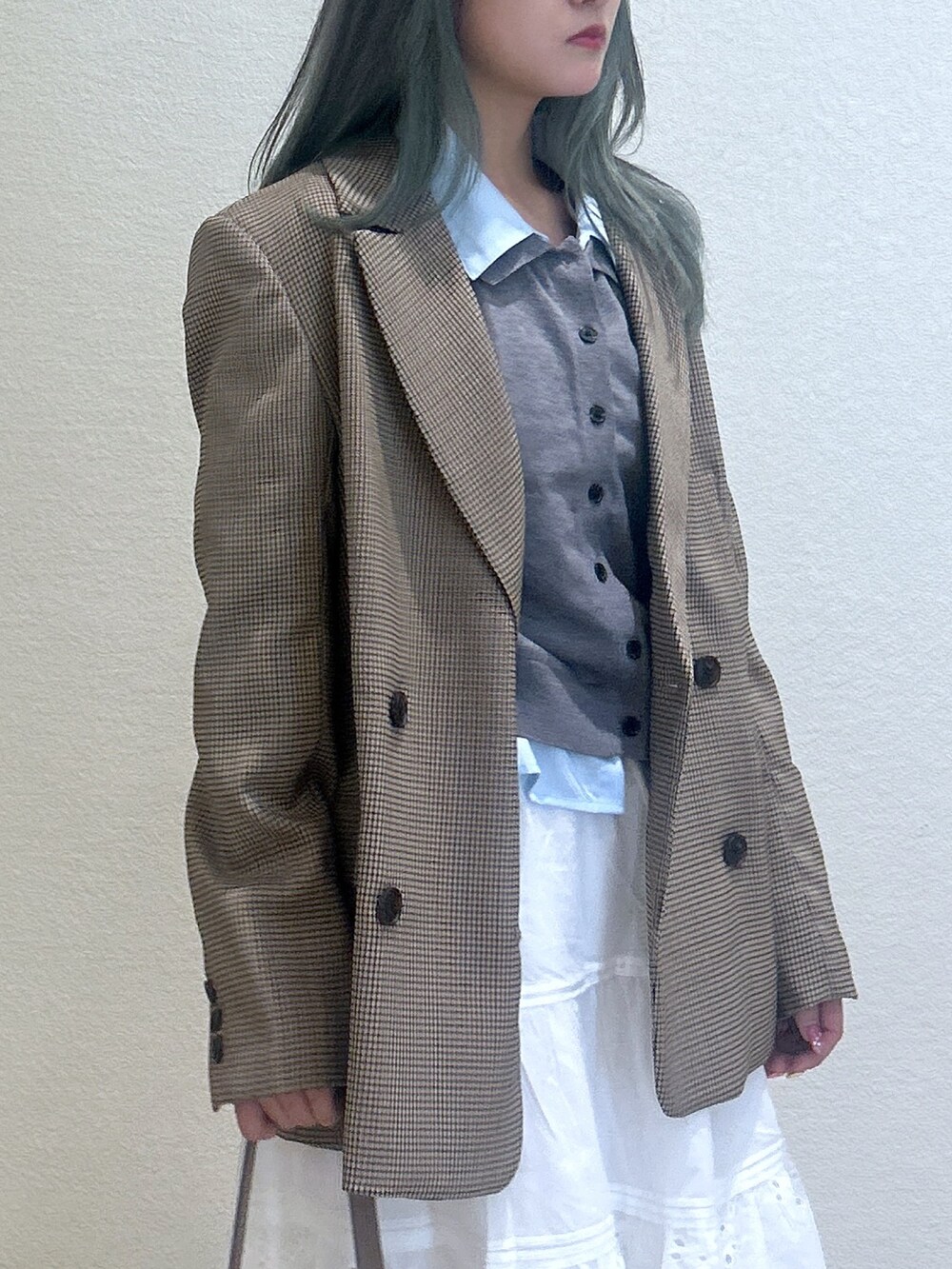 ホワイト系のパンプス、ホワイト系のスカート、ベージュ系のテーラードジャケットを着用したレディースの秋コーディネートの2枚目の写真