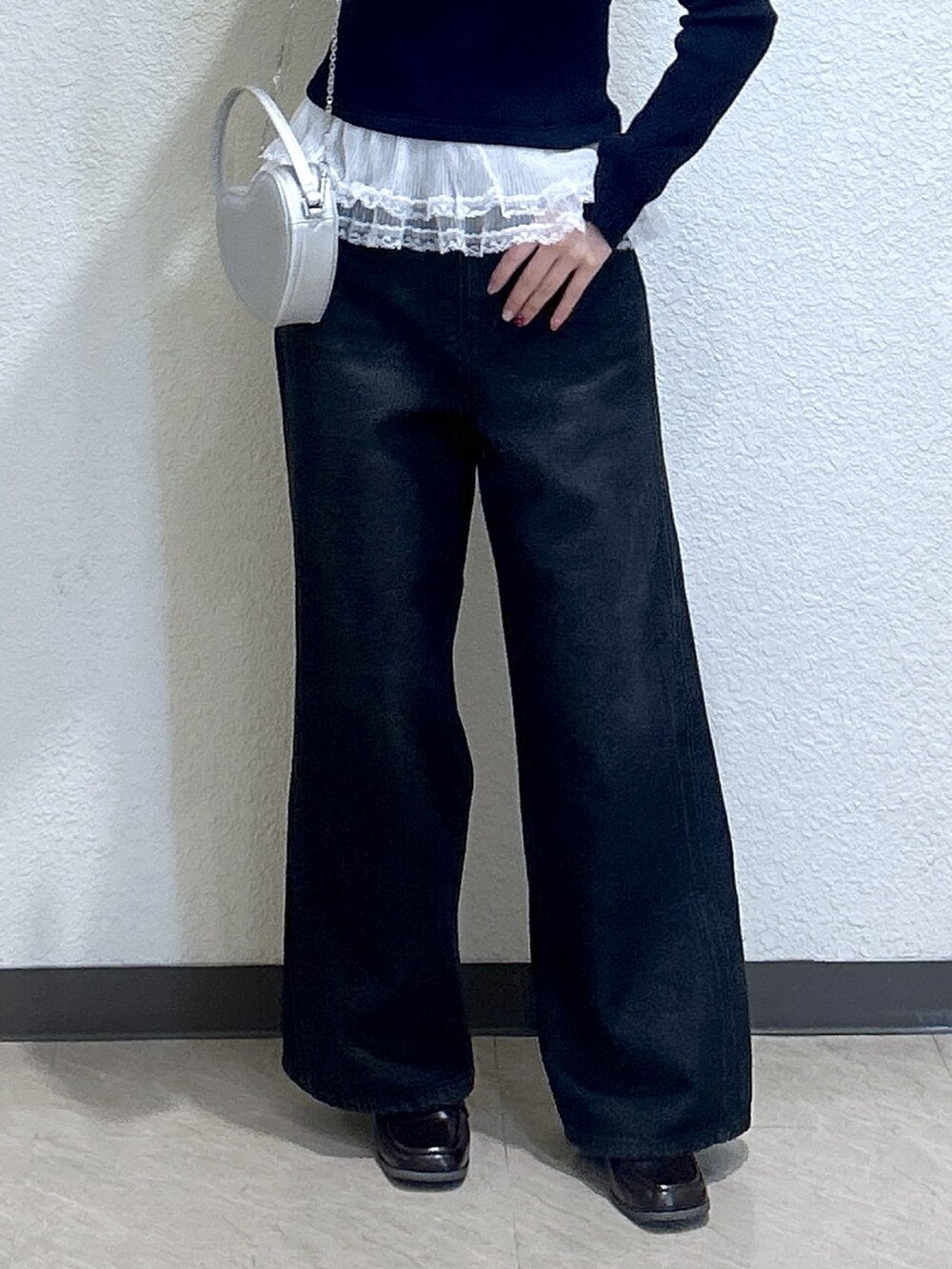 ブルー系のニット/セーター、ブルー系のデニムパンツ、ブラック系のショルダーバッグを着用したレディースの冬コーディネートの3枚目の写真