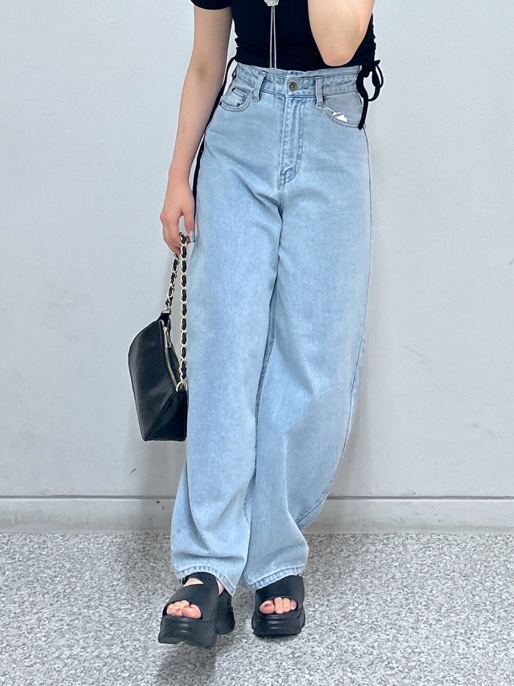 グリーン系のTシャツ/カットソー、ブルー系のデニムパンツ、ブラック系のトートバッグを着用したレディースの秋コーディネートの3枚目の写真