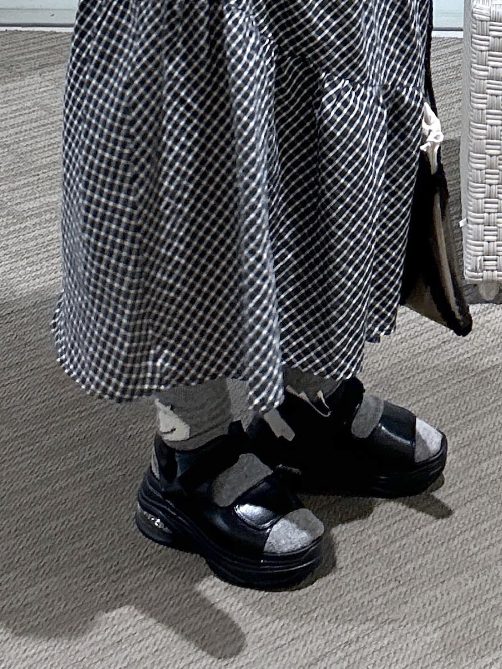 ブラック系のワンピース、ホワイト系のパーカー、ブラック系のサンダルを着用したレディースの春コーディネートの3枚目の写真