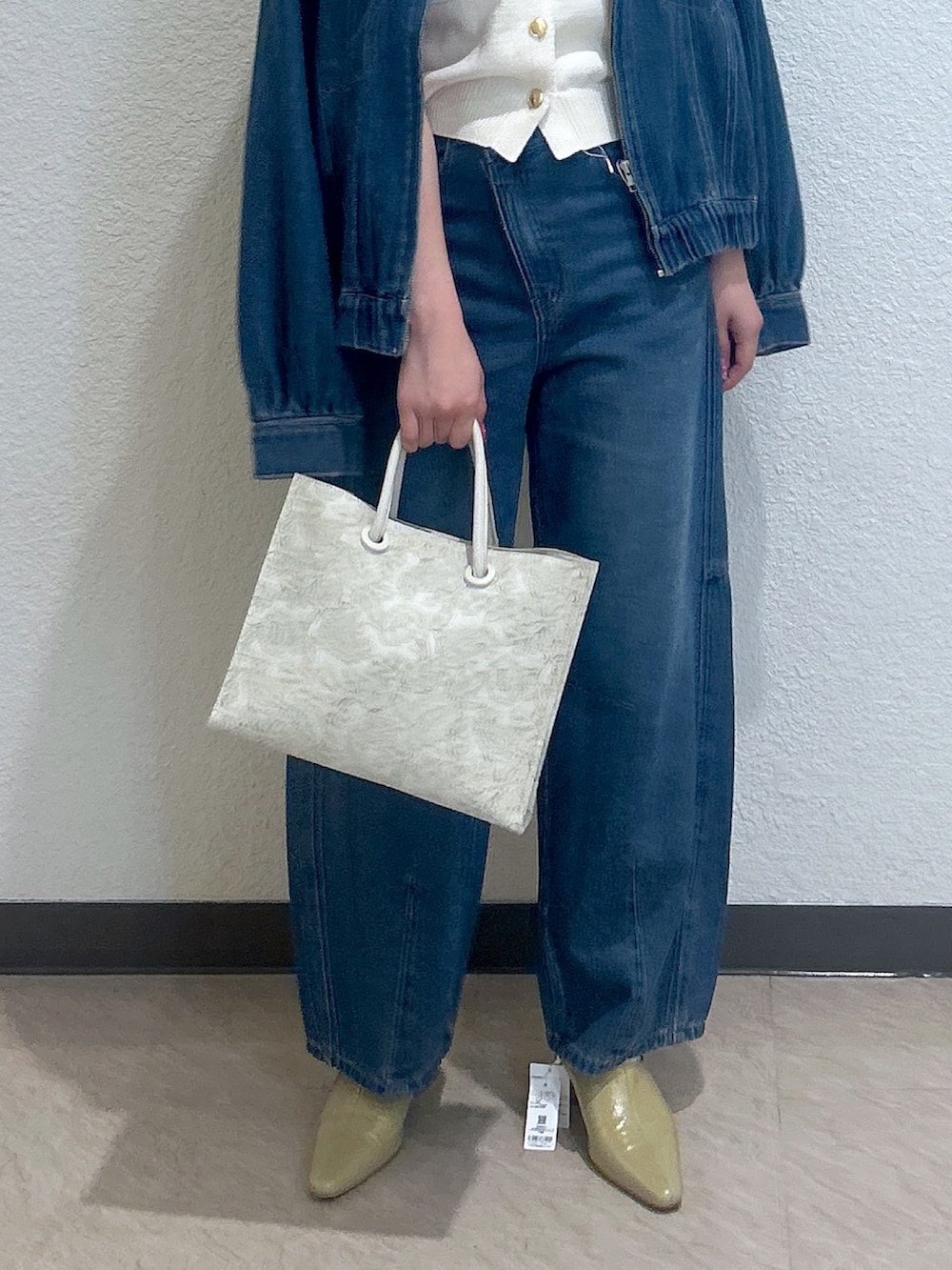 ブルー系のデニムジャケット、ブルー系のデニムパンツ、ベージュ系のパンプスを着用したレディースの秋コーディネートの3枚目の写真