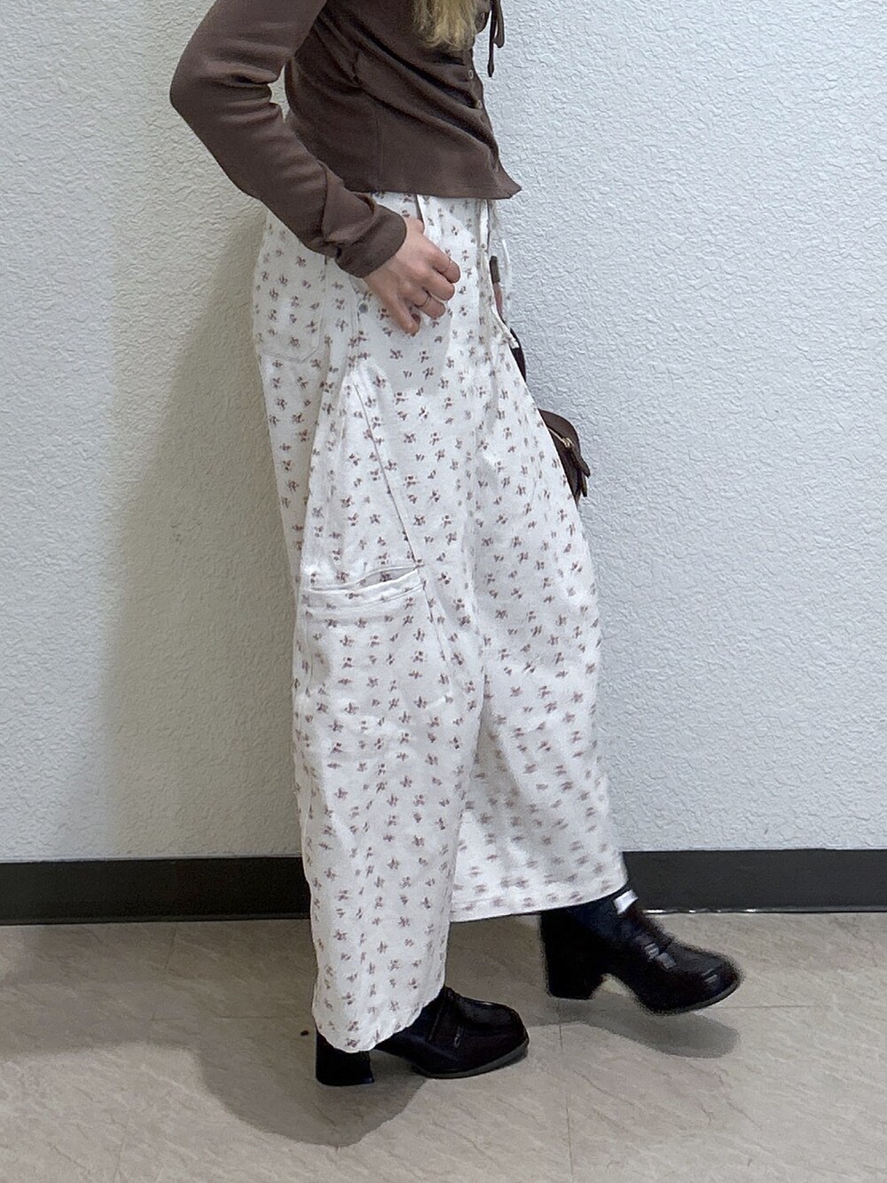 ホワイト系のデニムパンツ、グレー系のTシャツ/カットソー、ブラック系のハンドバッグを着用したレディースの冬コーディネートの3枚目の写真