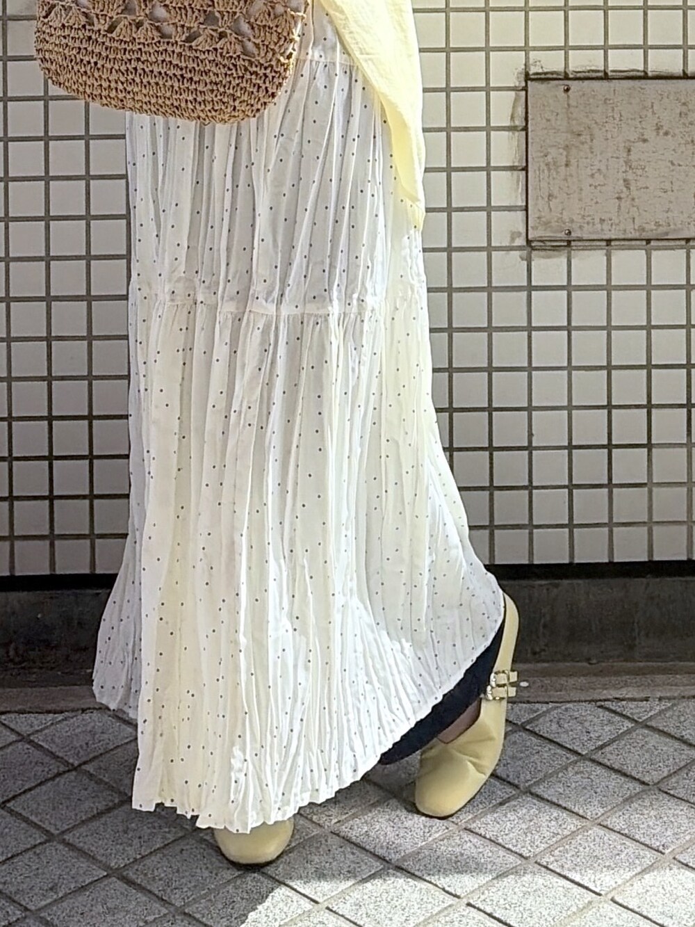 イエロー系のシャツ/ブラウス、ホワイト系のワンピース、ブルー系のデニムパンツを着用したレディースの春コーディネートの3枚目の写真