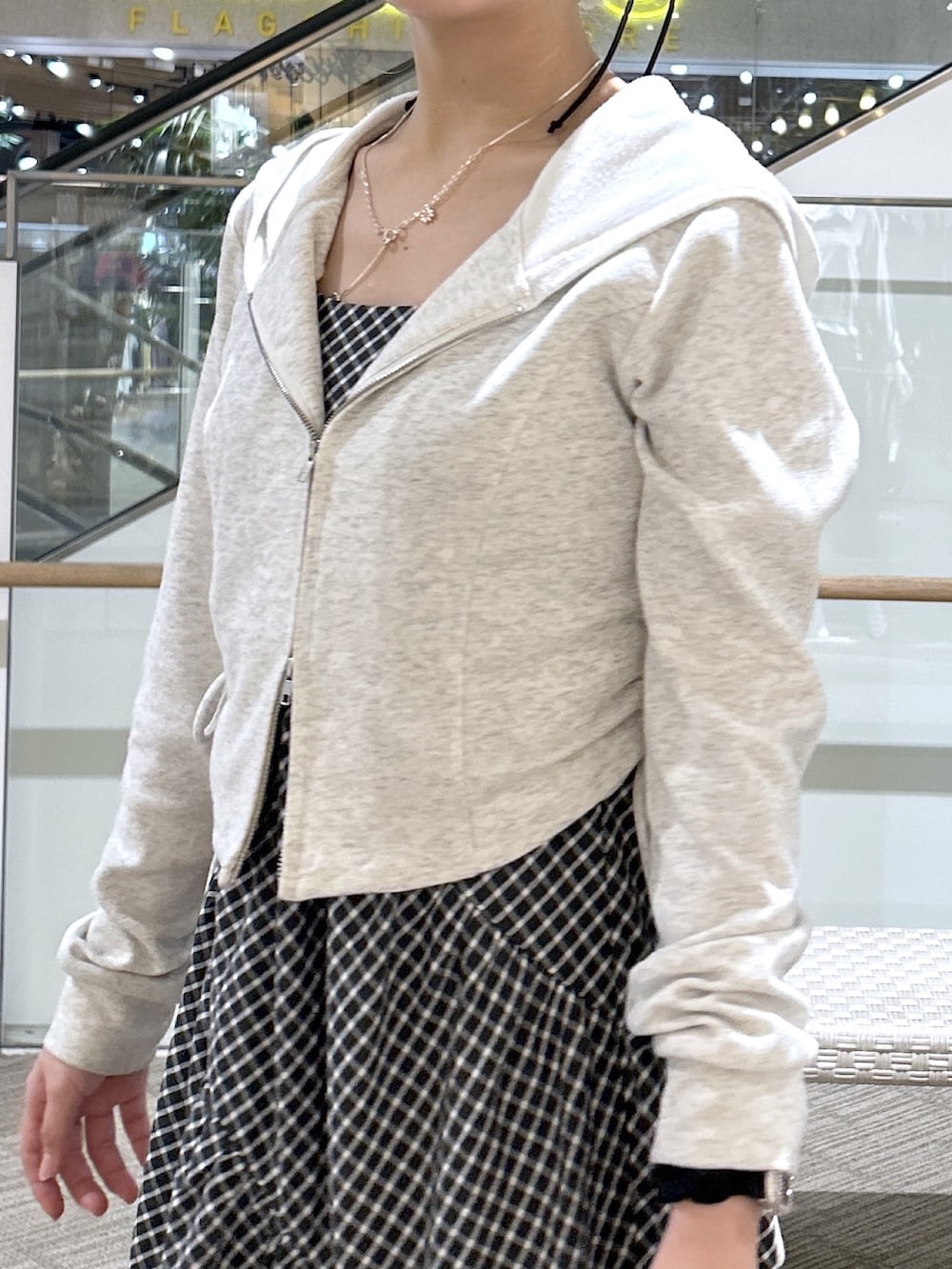 ブラック系のワンピース、ホワイト系のパーカー、ブラック系のサンダルを着用したレディースの春コーディネートの2枚目の写真