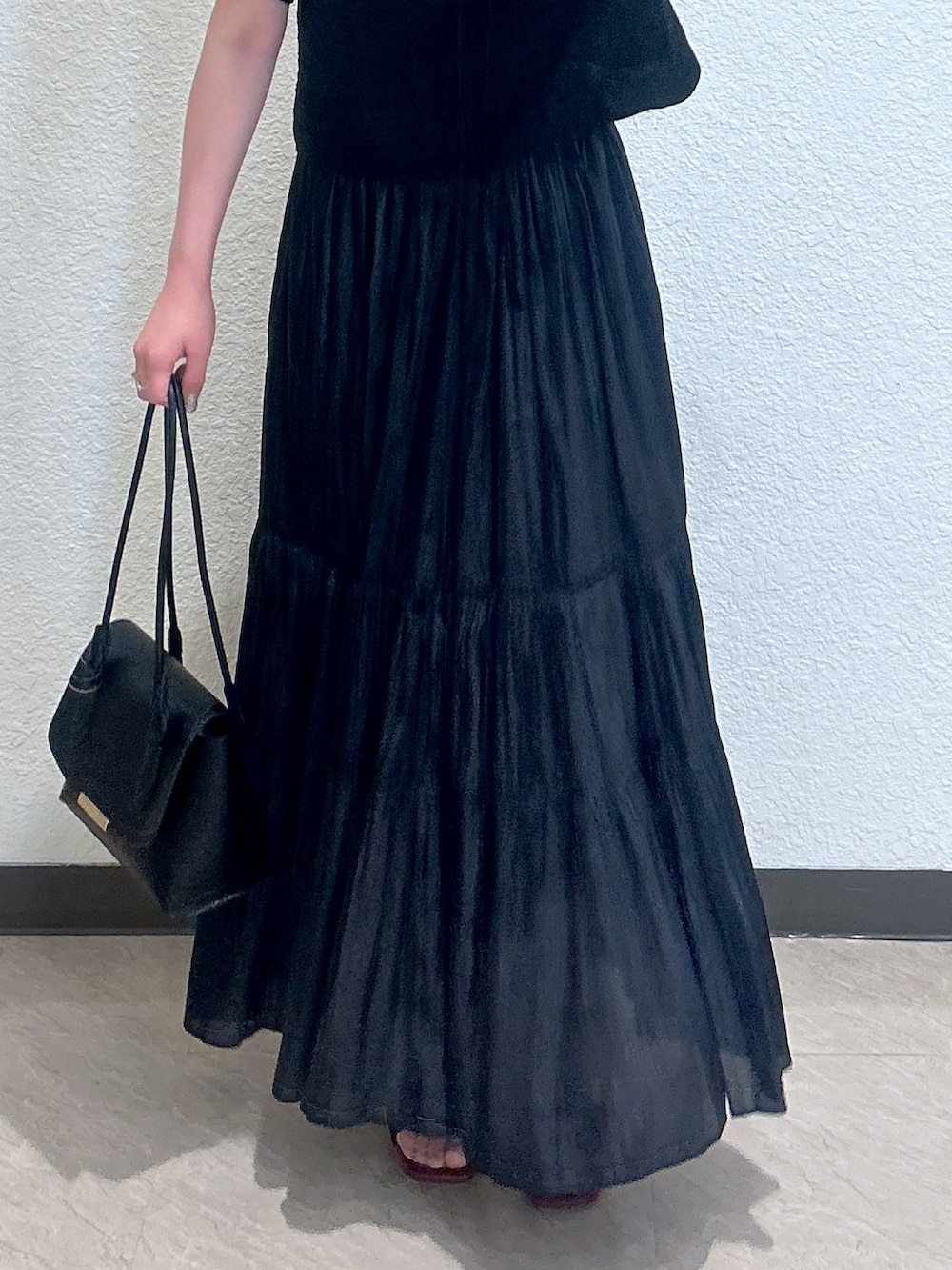 ブラック系のスカート、ブラック系のシャツ/ブラウス、ブラック系のショルダーバッグを着用したレディースの夏コーディネートの3枚目の写真