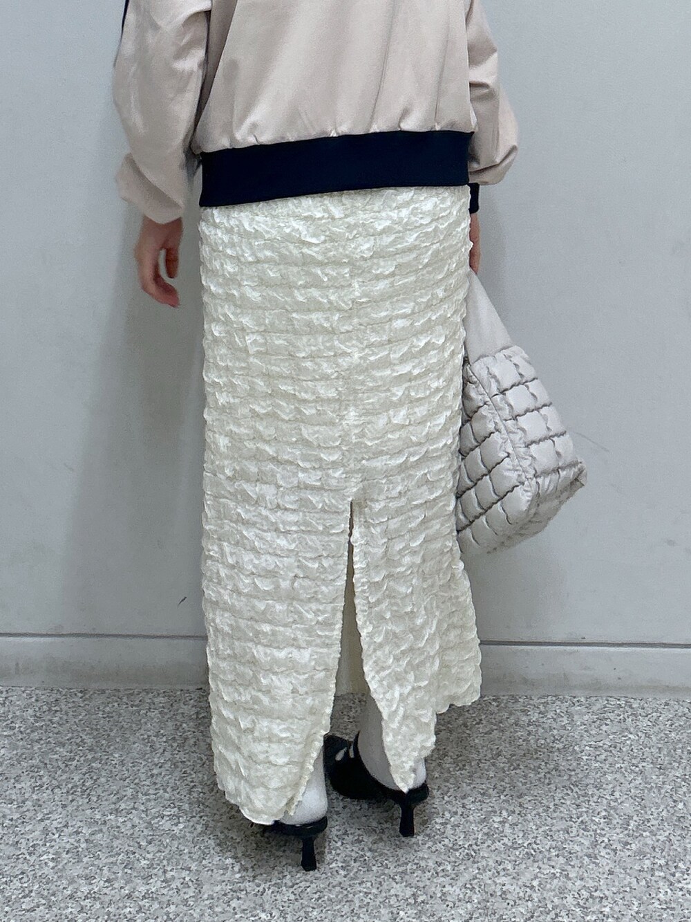 ホワイト系のスカート、ベージュ系のブルゾン、ブルー系のその他シューズを着用したレディースの秋コーディネートの3枚目の写真