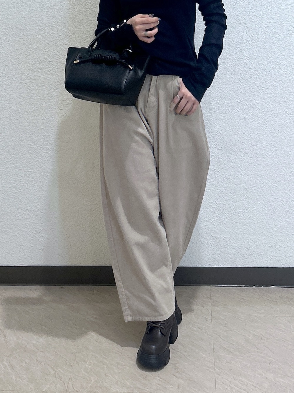 ベージュ系のその他パンツ、ブラック系のトートバッグ、ブルー系のニット/セーターを着用したレディースの秋コーディネートの3枚目の写真