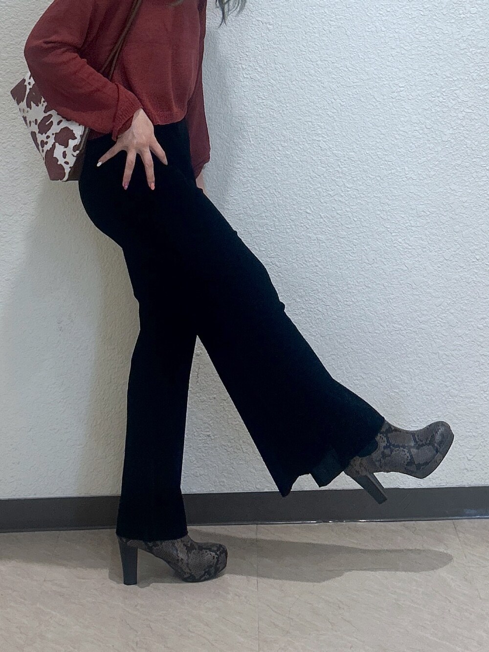 ブラウン系のブーツ、ブラック系のその他パンツ、ブラウン系のショルダーバッグを着用したレディースの秋コーディネートの3枚目の写真