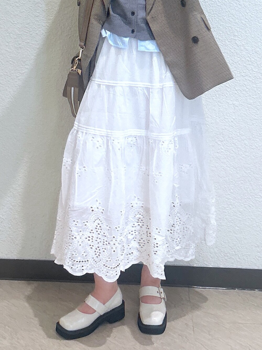 ホワイト系のパンプス、ホワイト系のスカート、ベージュ系のテーラードジャケットを着用したレディースの秋コーディネートの3枚目の写真