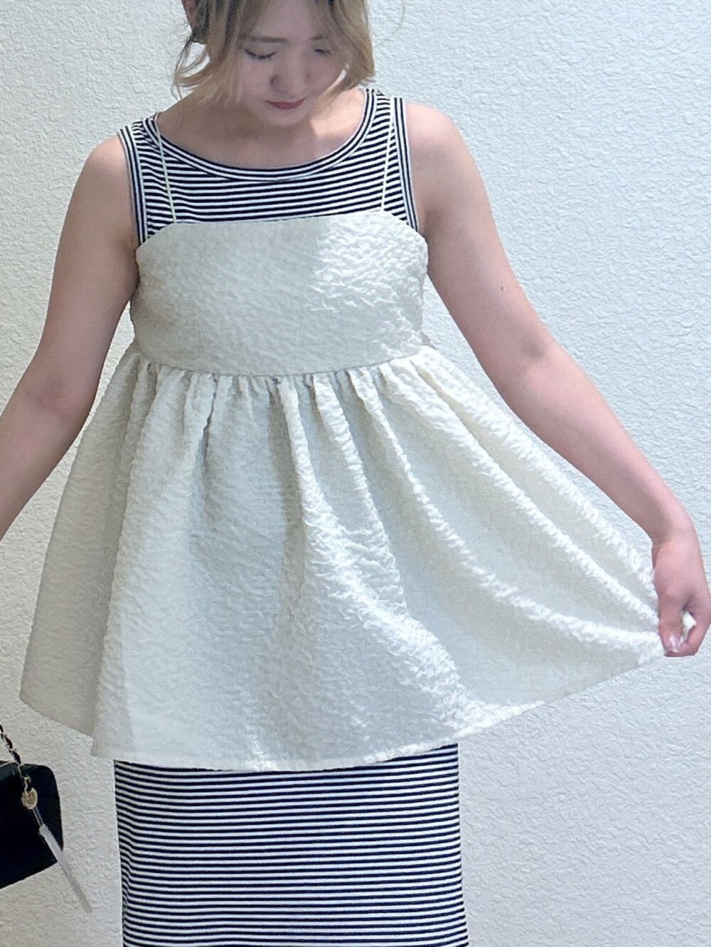 ブルー系のワンピース、ホワイト系のキャミソール、レッド系のショルダーバッグを着用したレディースの夏コーディネートの2枚目の写真