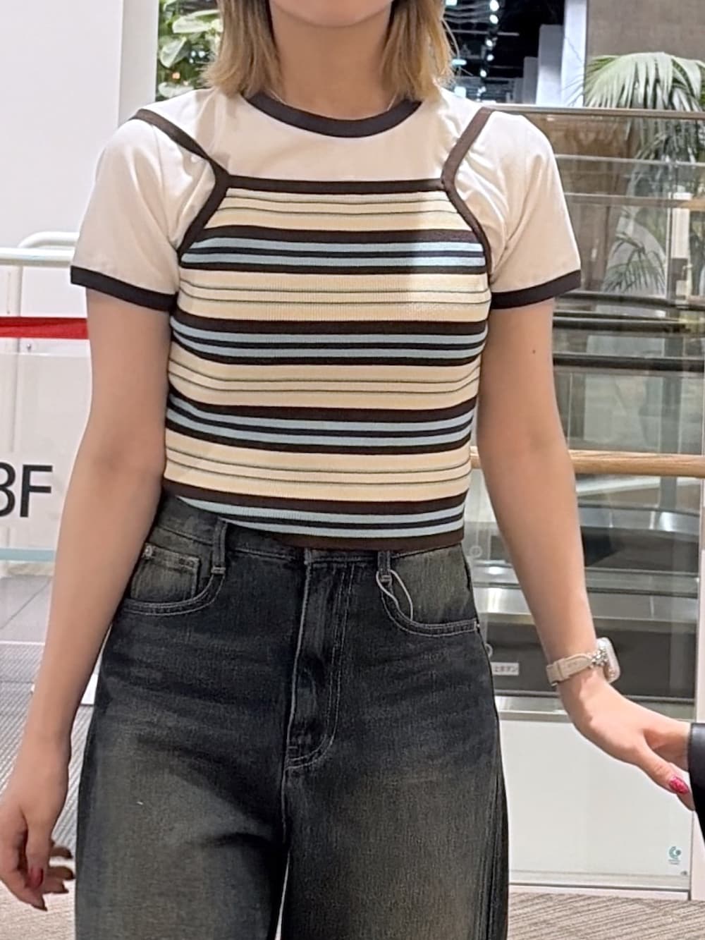 ブラウン系のTシャツ/カットソー、ブルー系のニット/セーター、ブラック系のショルダーバッグを着用したレディースの夏コーディネートの2枚目の写真