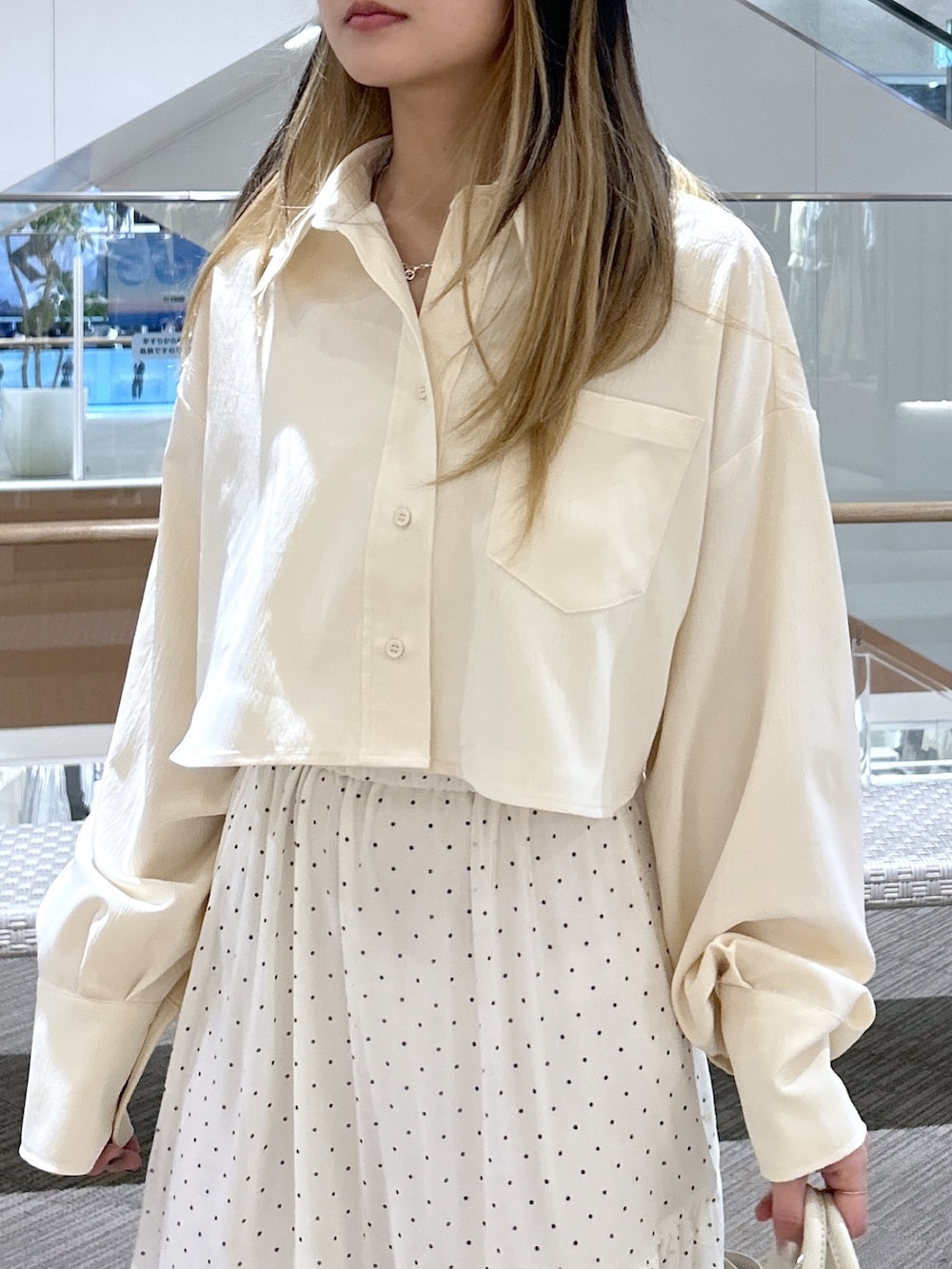 ホワイト系のシャツ/ブラウス、ブラック系のトートバッグ、ホワイト系のスカートを着用したレディースの春コーディネートの2枚目の写真