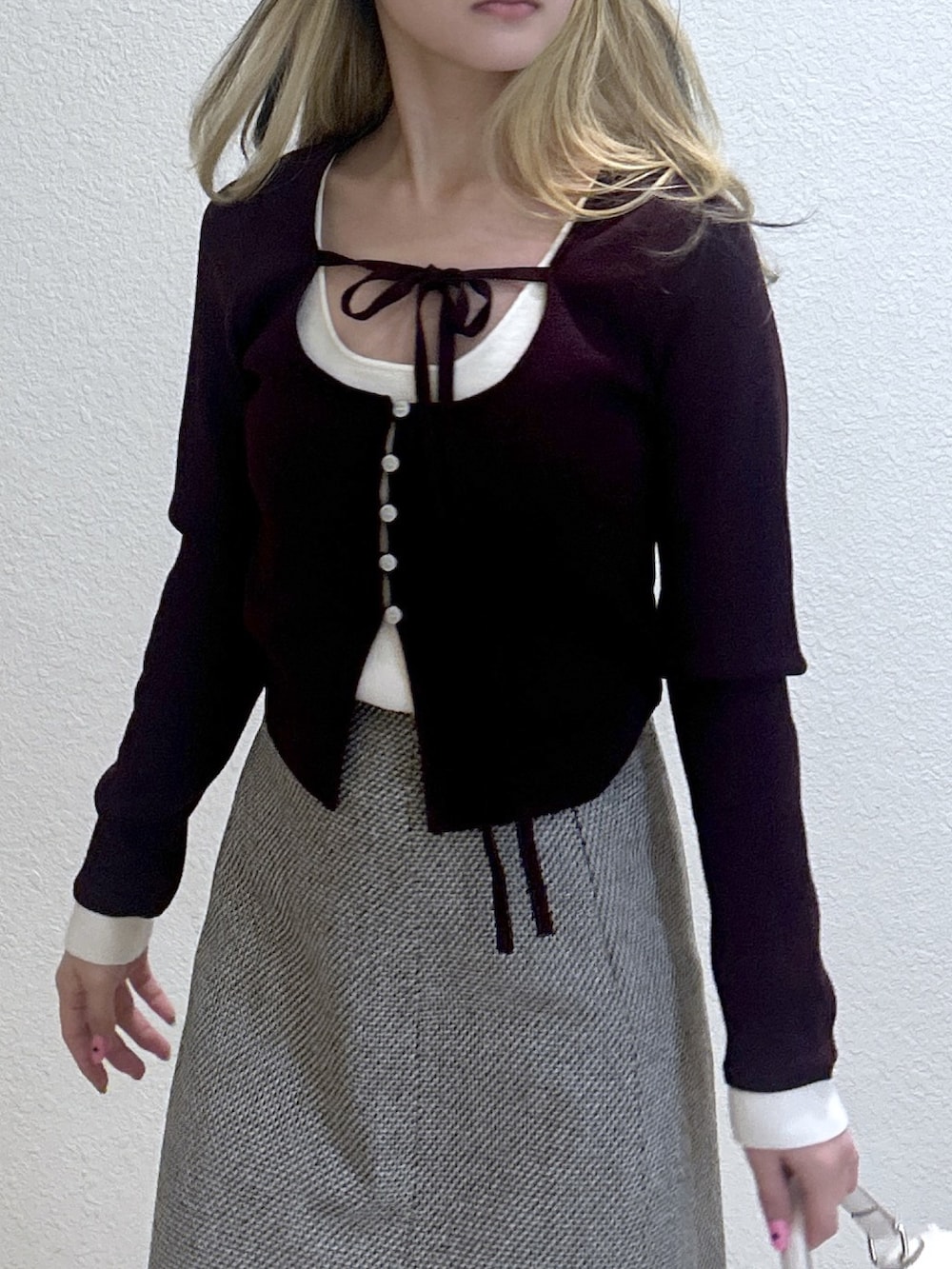 レッド系のニット/セーター、ホワイト系のトートバッグ、ブラック系のブーツを着用したレディースの冬コーディネートの2枚目の写真