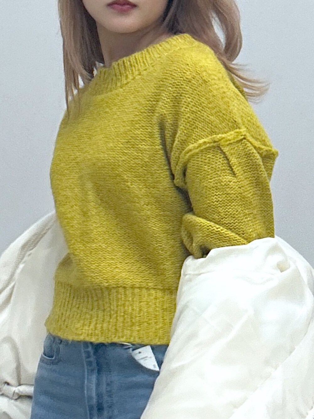 グリーン系のブルゾン、ブルー系のデニムパンツ、グレー系のニット/セーターを着用したレディースの冬コーディネートの3枚目の写真