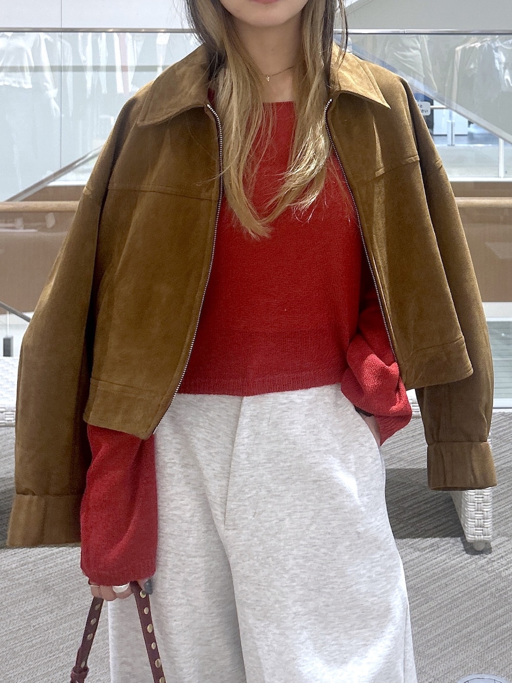 ホワイト系のその他パンツ、レッド系のニット/セーター、ブラウン系のブルゾンを着用したレディースの春コーディネートの2枚目の写真