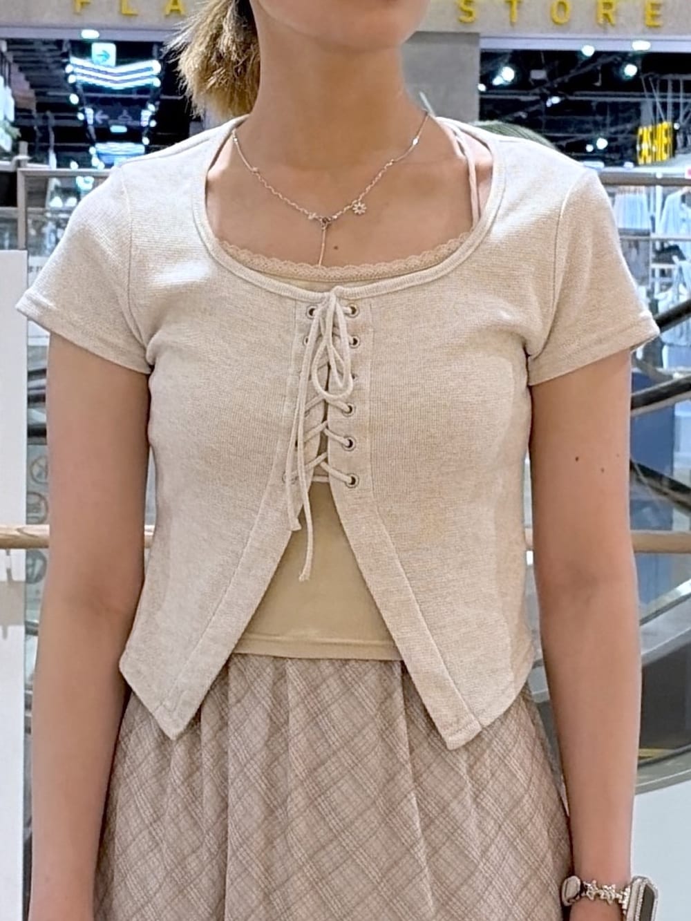 ホワイト系のスカート、ベージュ系のTシャツ/カットソー、ブラック系のパンプスを着用したレディースの夏コーディネートの2枚目の写真