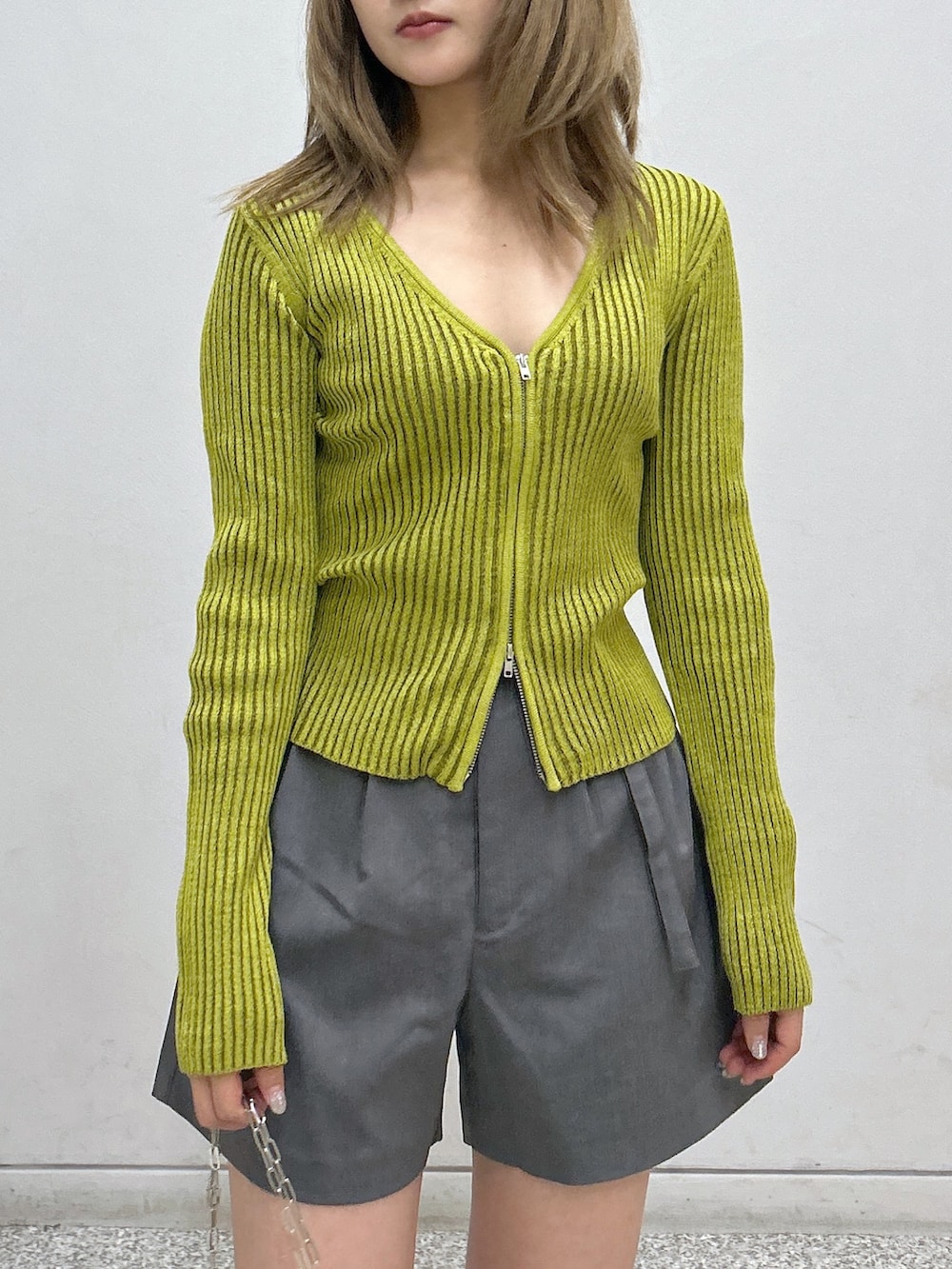 グレー系のその他パンツ、グリーン系のニット/セーター、ブラック系のハンドバッグを着用したレディースの秋コーディネートの2枚目の写真