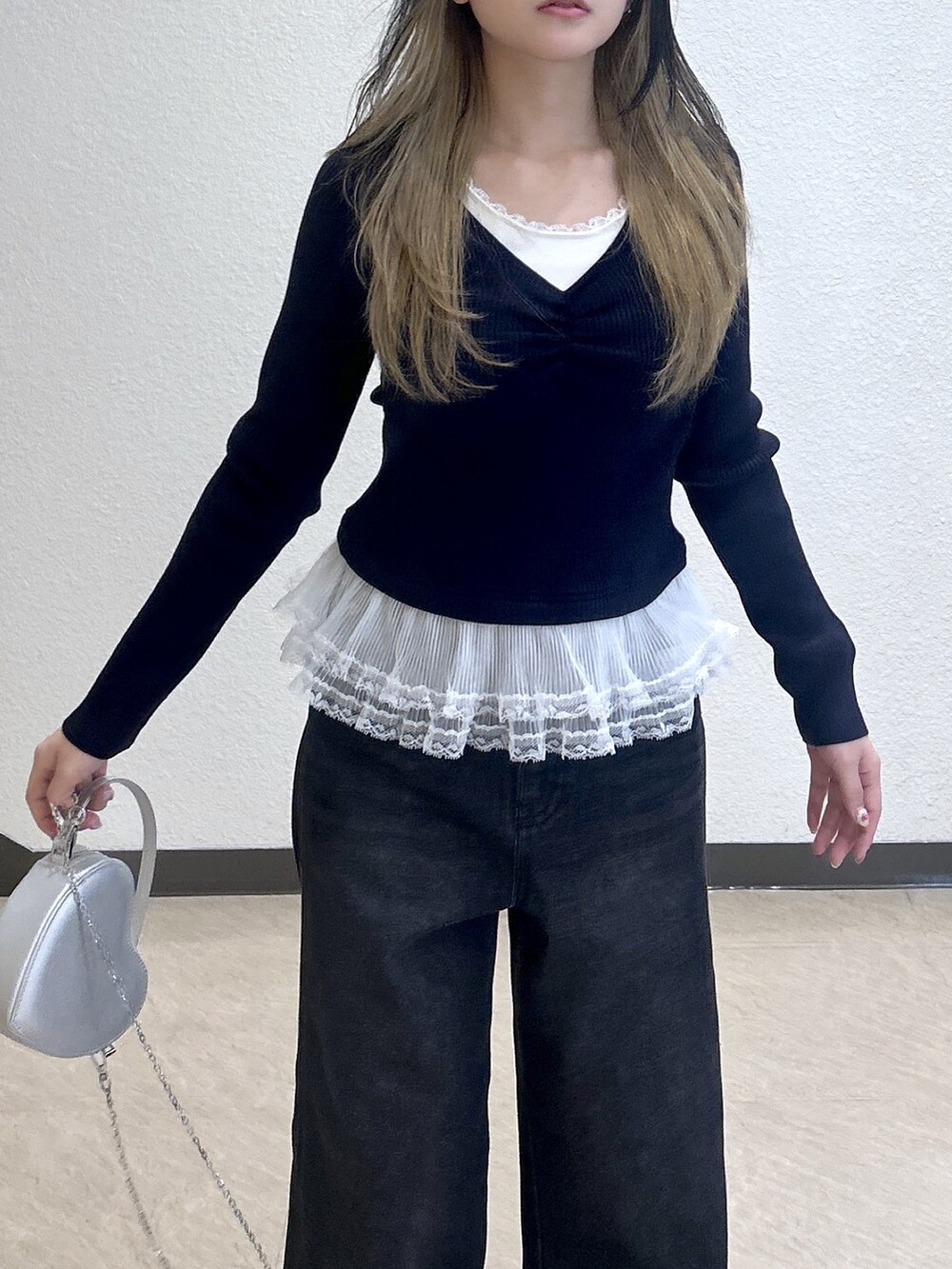 ブルー系のニット/セーター、ブルー系のデニムパンツ、ブラック系のショルダーバッグを着用したレディースの冬コーディネートの2枚目の写真