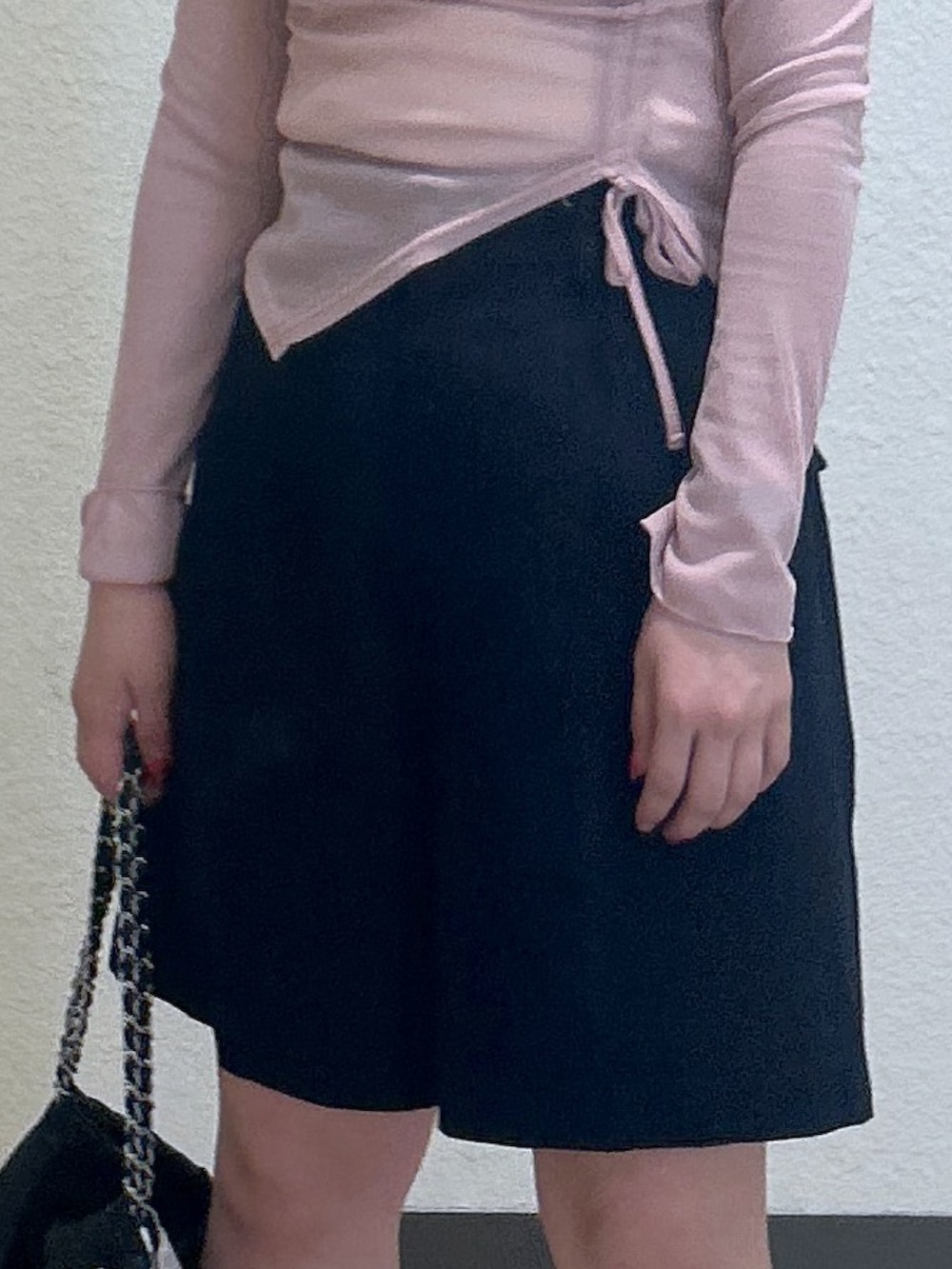 ブルー系のチノパンツ、ブラック系のパンプス、ブラック系のハンドバッグを着用したレディースの春コーディネートの3枚目の写真