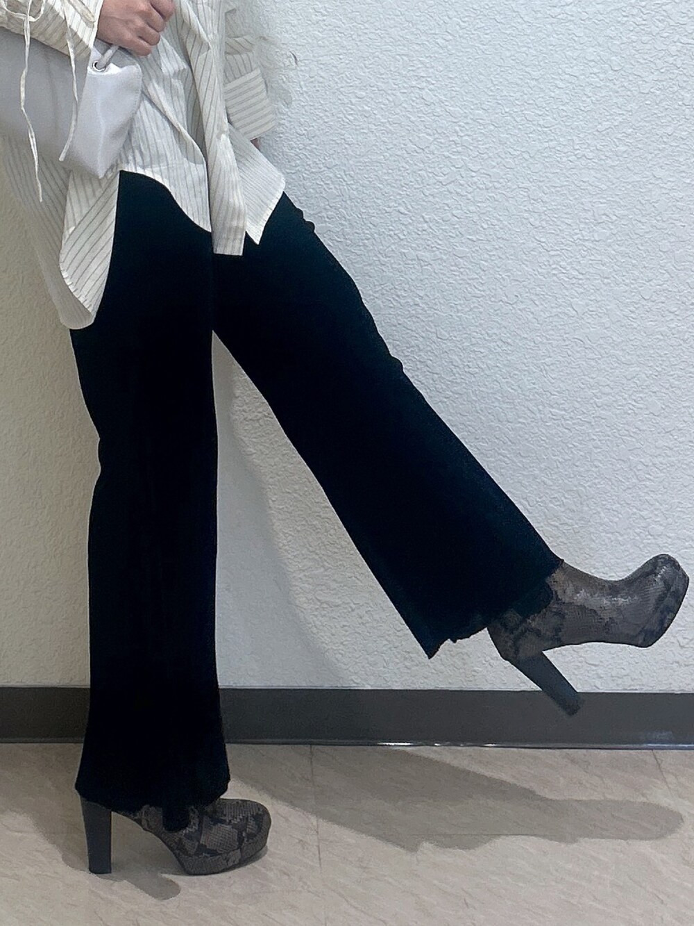 ブラック系のその他パンツ、ホワイト系のシャツ/ブラウス、ブラウン系のショルダーバッグを着用したレディースの秋コーディネートの3枚目の写真