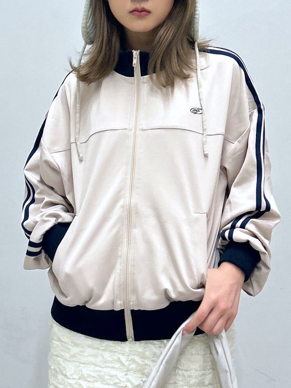 ホワイト系のスカート、ベージュ系のブルゾン、ブルー系のその他シューズを着用したレディースの秋コーディネートの2枚目の写真