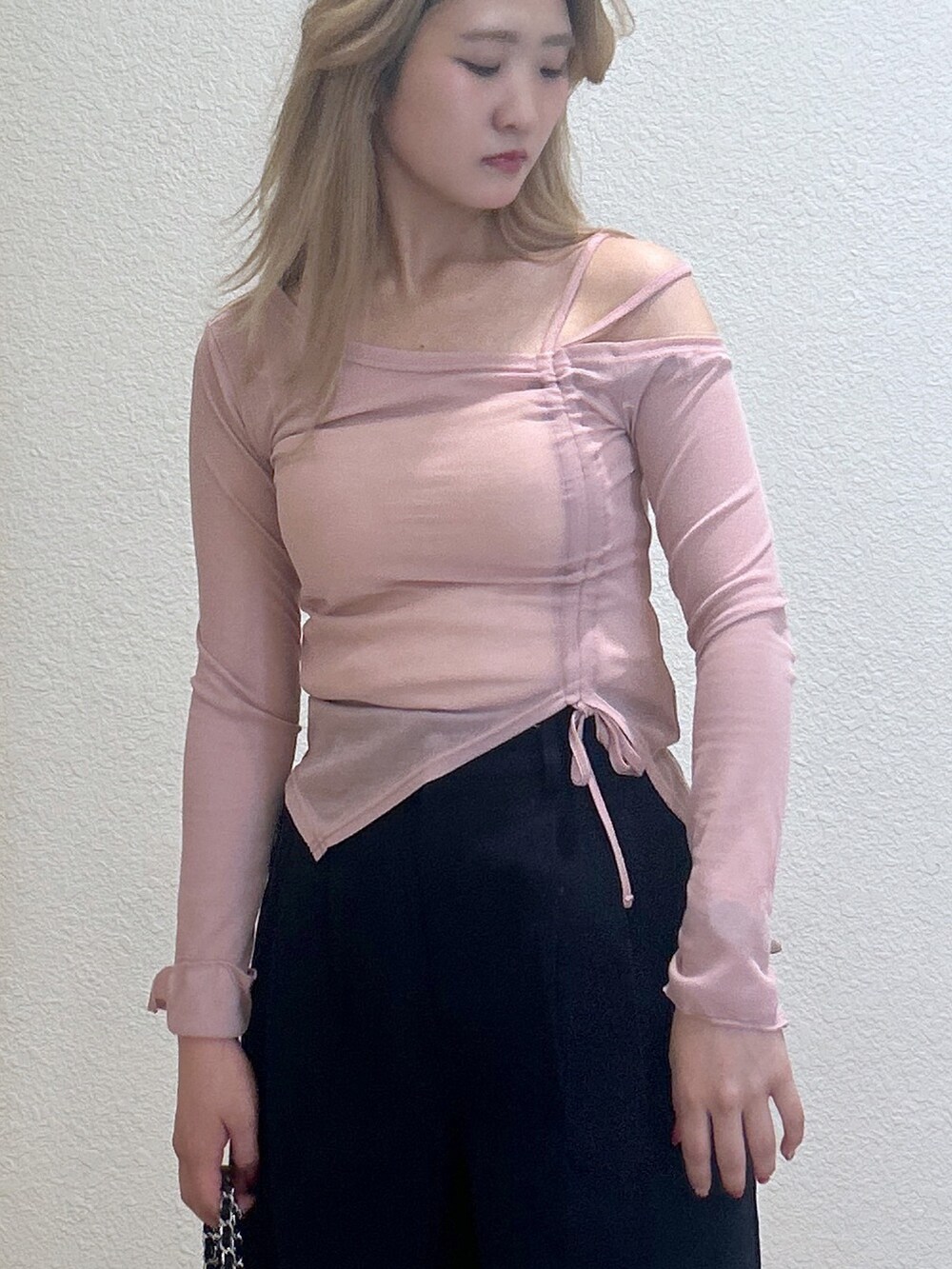 ブルー系のチノパンツ、ブラック系のパンプス、ブラック系のハンドバッグを着用したレディースの春コーディネートの2枚目の写真