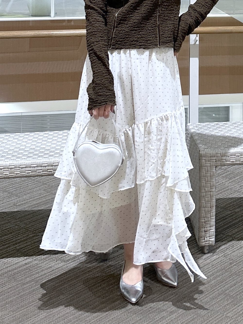 ブラウン系のTシャツ/カットソー、ホワイト系のスカート、ブラック系のショルダーバッグを着用したレディースの春コーディネートの3枚目の写真