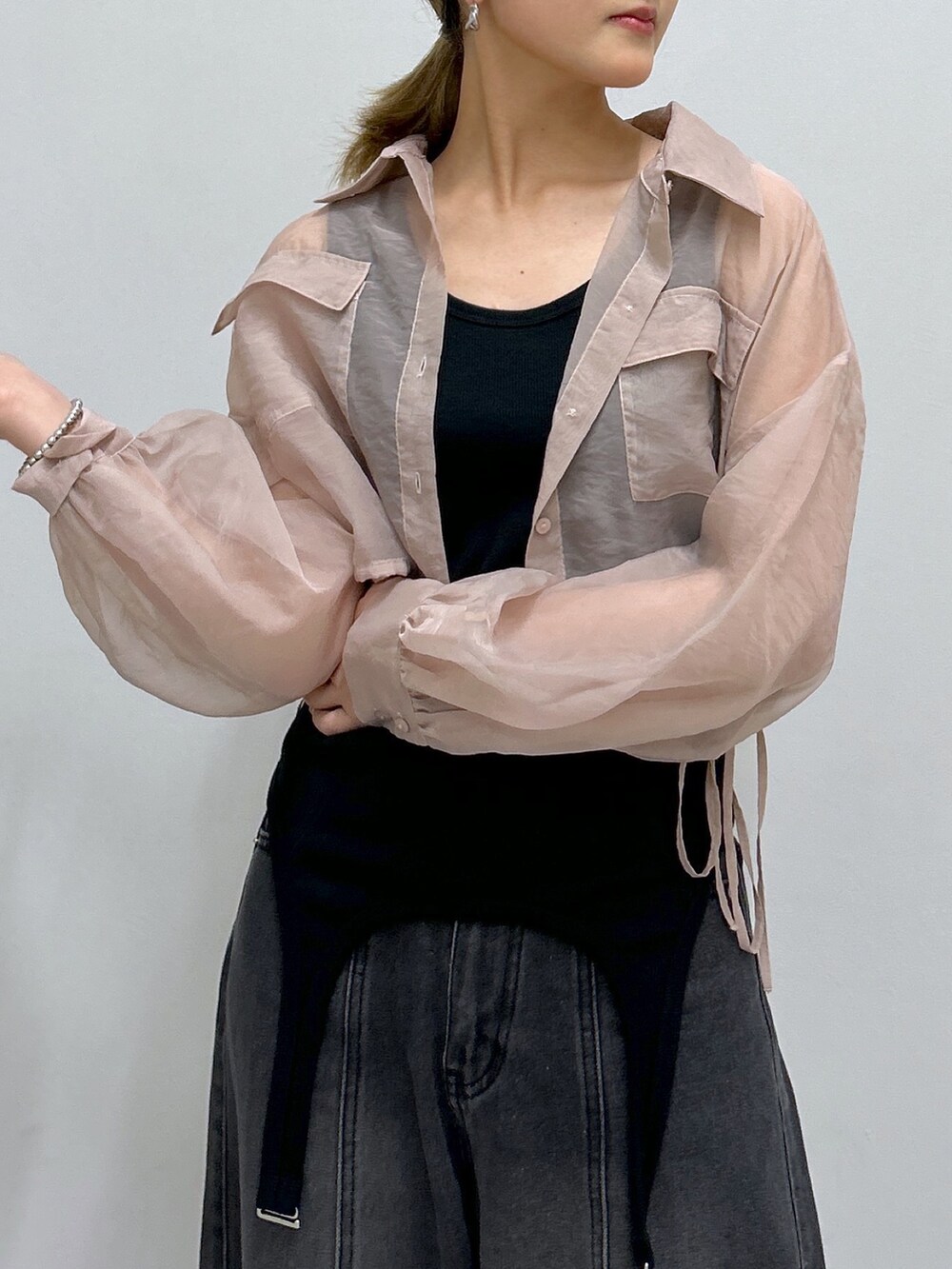 ブラック系のデニムパンツ、ブラック系のサンダル、ピンク系のシャツ/ブラウスを着用したレディースの夏コーディネートの2枚目の写真