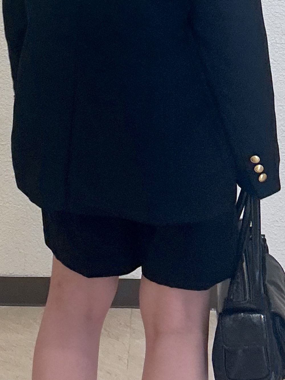 ブルー系のチノパンツ、ブラック系のショルダーバッグ、ブラック系のパンプスを着用したレディースの春コーディネートの4枚目の写真