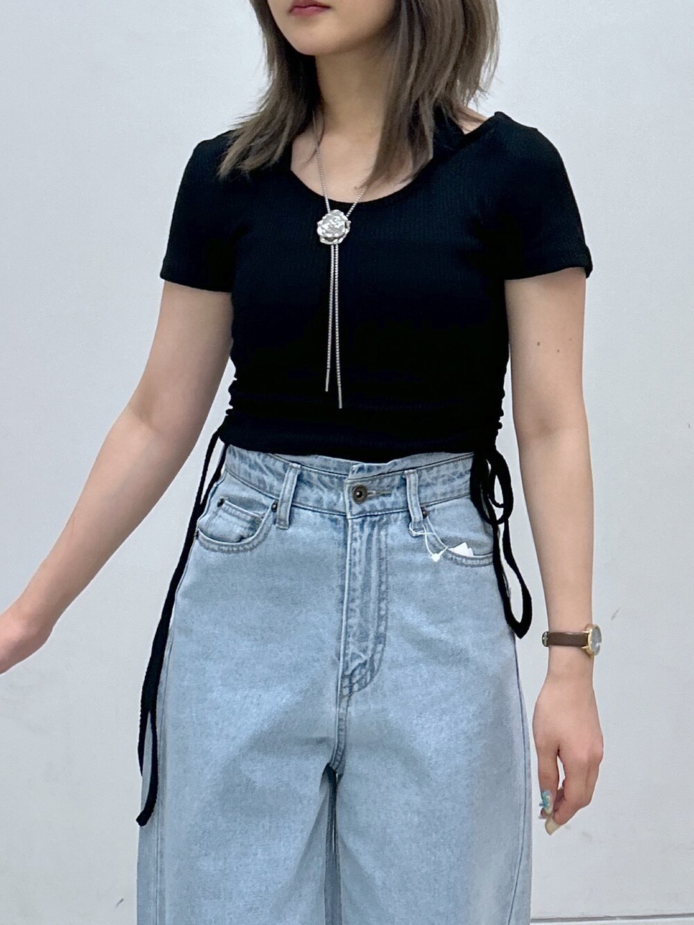 グリーン系のTシャツ/カットソー、ブルー系のデニムパンツ、ブラック系のトートバッグを着用したレディースの秋コーディネートの2枚目の写真