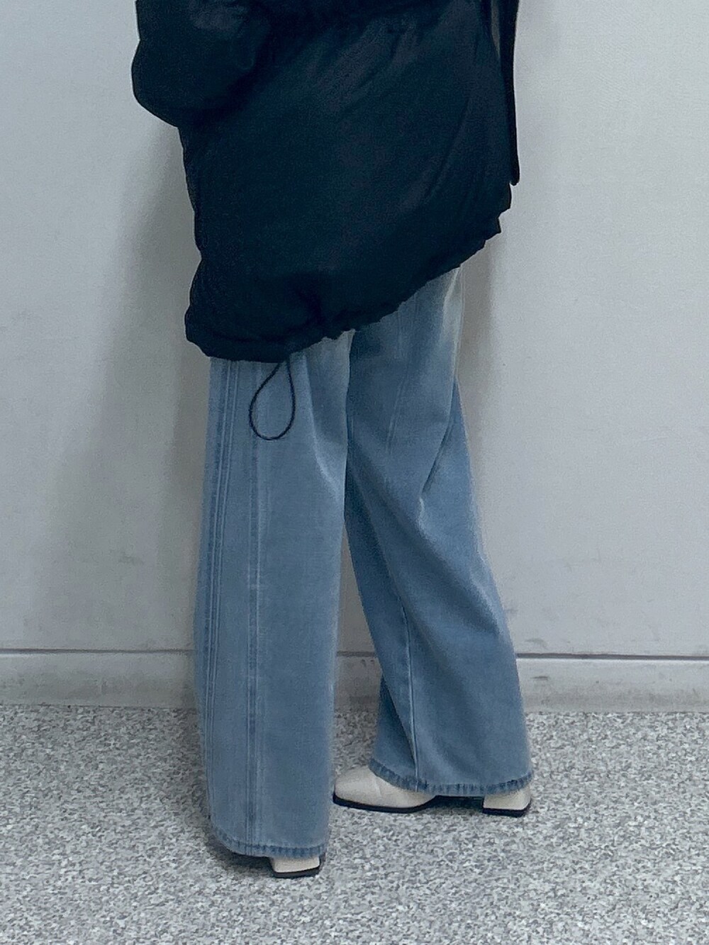 ブラック系のブルゾン、ブルー系のデニムパンツ、ブラック系のショルダーバッグを着用したレディースの冬コーディネートの4枚目の写真