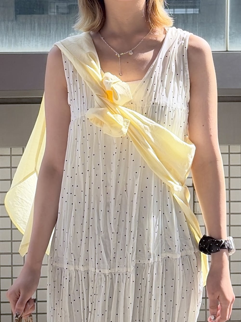 ホワイト系のワンピース、イエロー系のシャツ/ブラウス、イエロー系のパンプスを着用したレディースの夏コーディネートの2枚目の写真