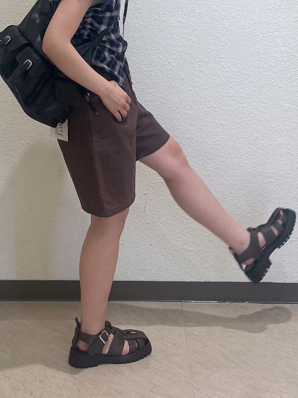 ブラウン系のデニムパンツ、ブラウン系のトートバッグ、ブラウン系のサンダルを着用したレディースの夏コーディネートの3枚目の写真