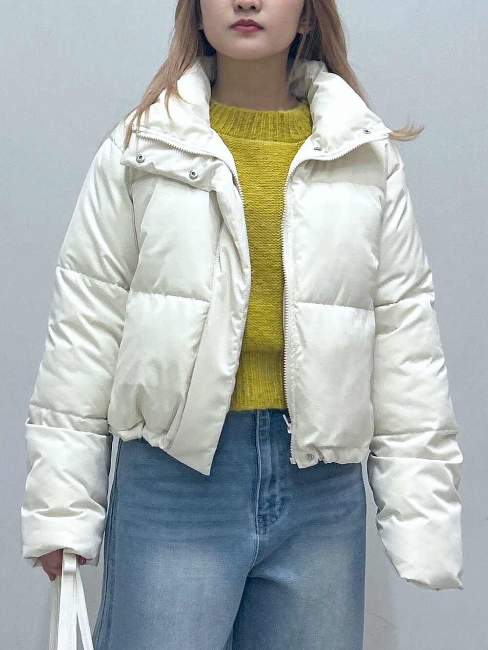 グリーン系のブルゾン、ブルー系のデニムパンツ、グレー系のニット/セーターを着用したレディースの冬コーディネートの2枚目の写真