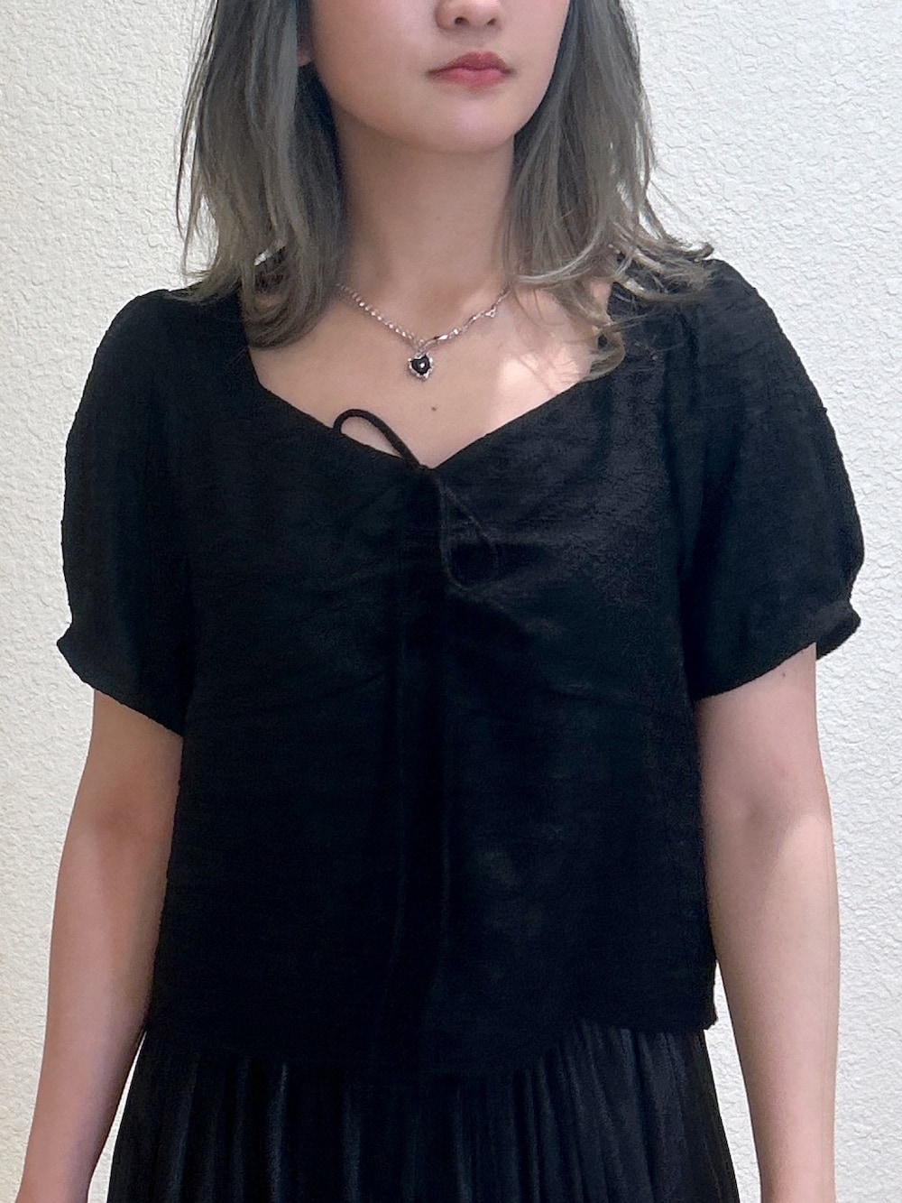 ブラック系のスカート、ブラック系のシャツ/ブラウス、ブラック系のショルダーバッグを着用したレディースの夏コーディネートの2枚目の写真