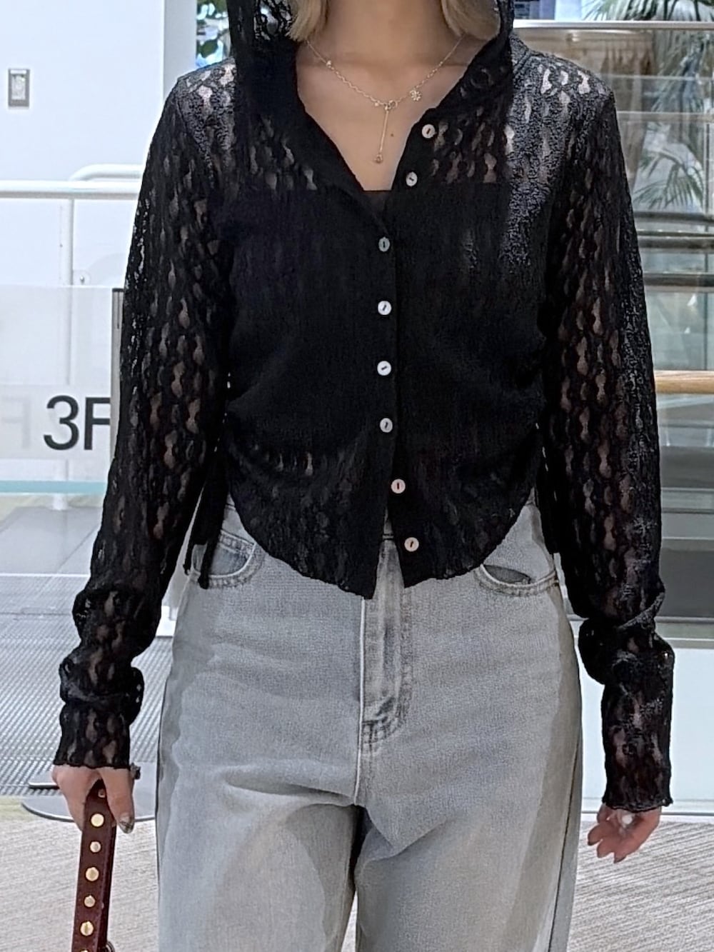 ブラック系のデニムパンツ、ブラック系のTシャツ/カットソー、レッド系のショルダーバッグを着用したレディースの夏コーディネートの2枚目の写真