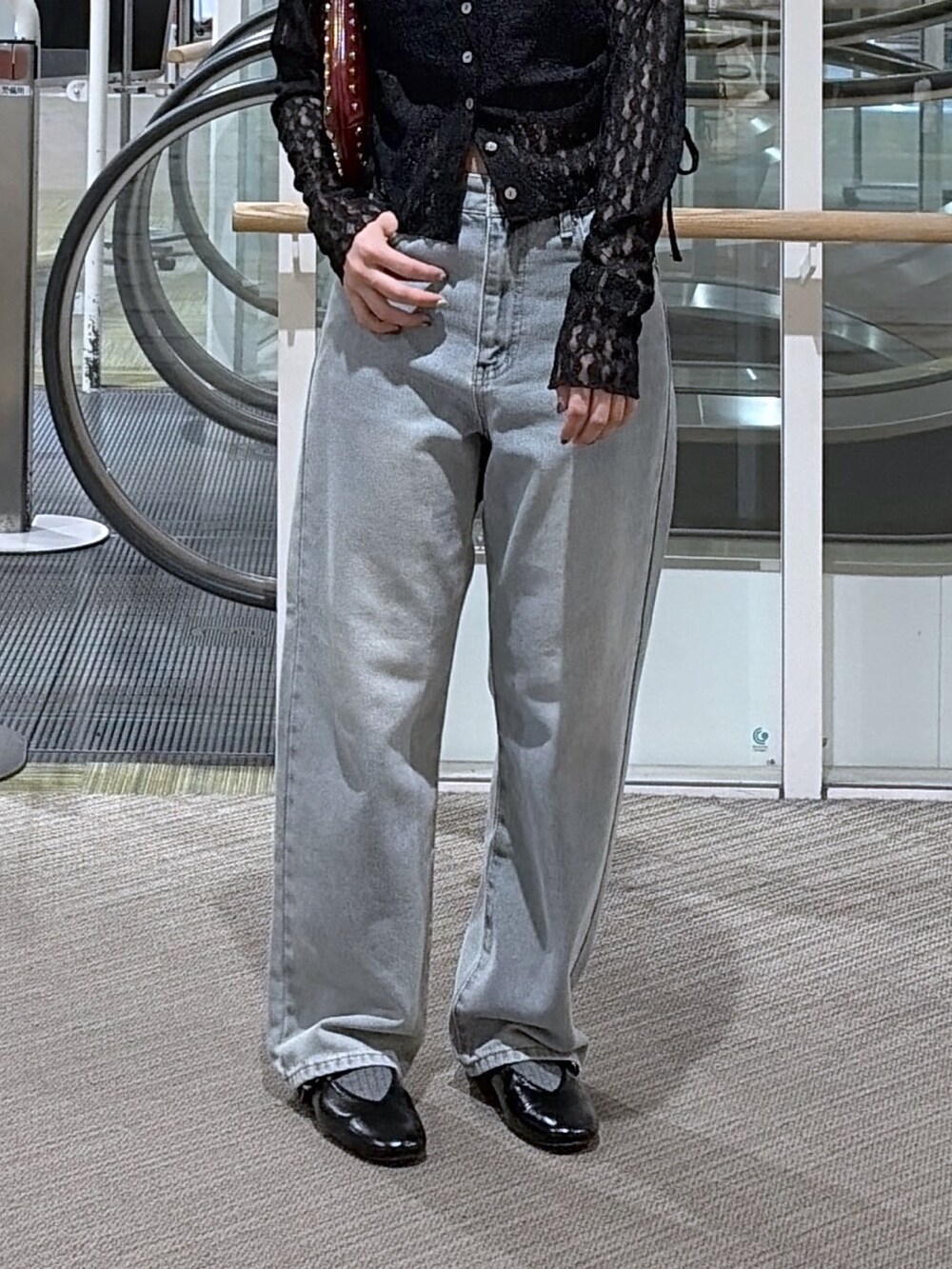 ブラック系のデニムパンツ、ブラック系のTシャツ/カットソー、レッド系のショルダーバッグを着用したレディースの夏コーディネートの3枚目の写真