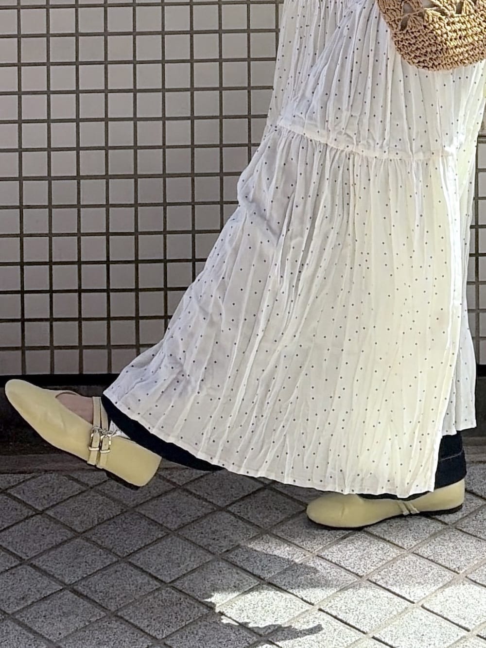 ホワイト系のワンピース、イエロー系のシャツ/ブラウス、イエロー系のパンプスを着用したレディースの夏コーディネートの3枚目の写真