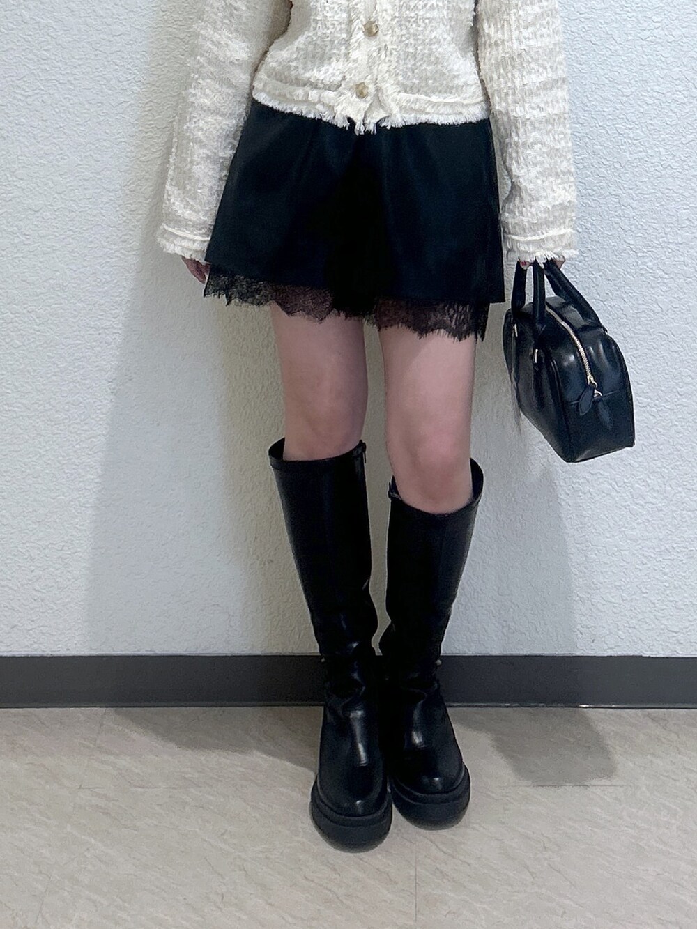 ブラック系のその他パンツ、ホワイト系のニット/セーター、ブラック系のハンドバッグを着用したレディースの冬コーディネートの3枚目の写真