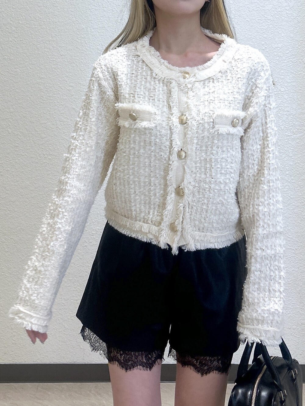 ブラック系のその他パンツ、ホワイト系のニット/セーター、ブラック系のハンドバッグを着用したレディースの冬コーディネートの2枚目の写真