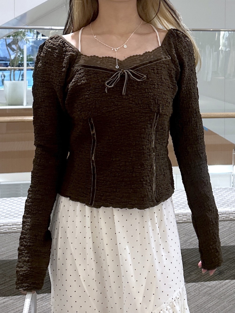 ブラウン系のTシャツ/カットソー、ホワイト系のスカート、ブラック系のショルダーバッグを着用したレディースの春コーディネートの2枚目の写真