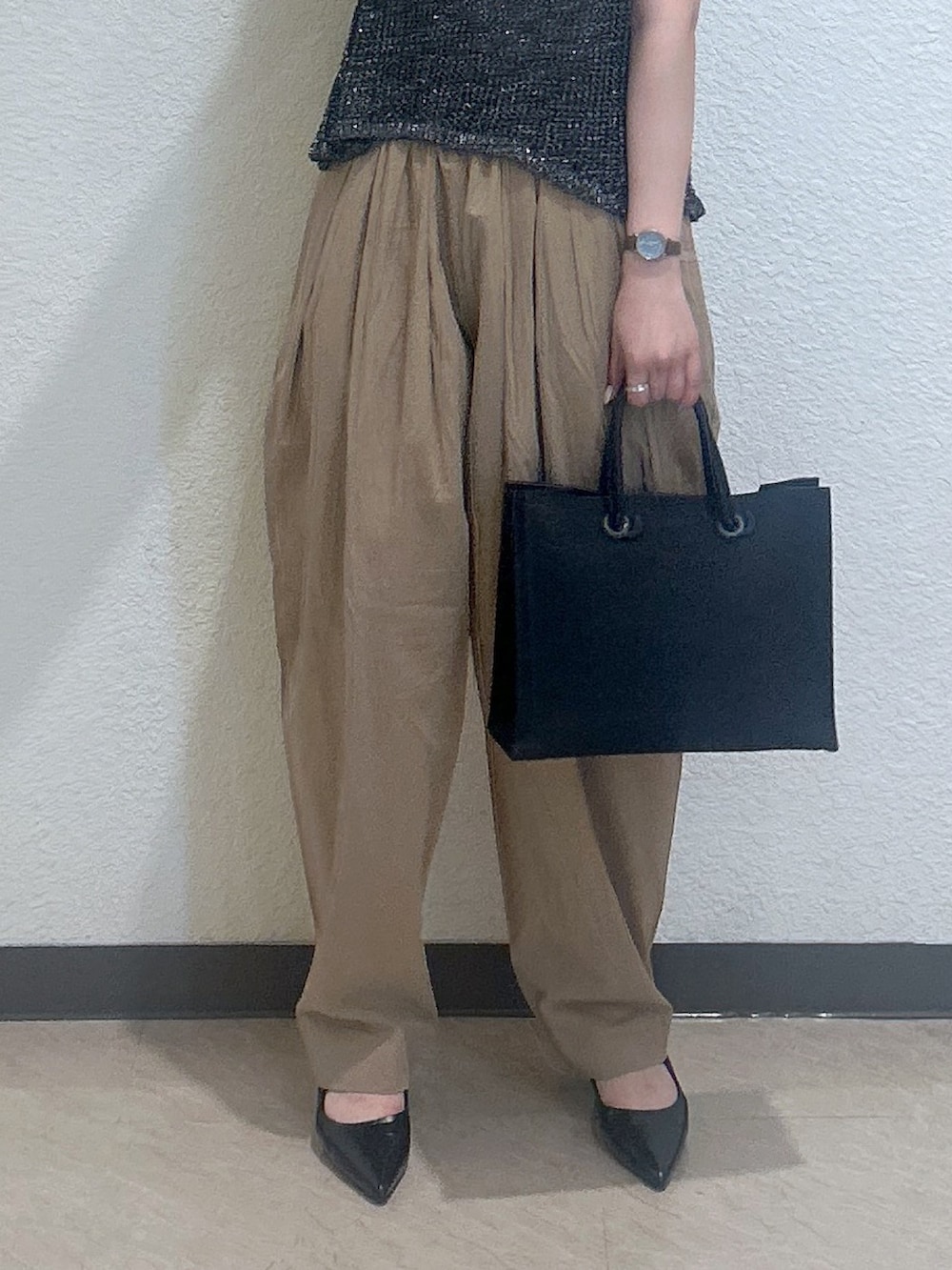 ブラック系のキャミソール、ゴールド系のベスト、ブラック系のトートバッグを着用したレディースの夏コーディネートの3枚目の写真