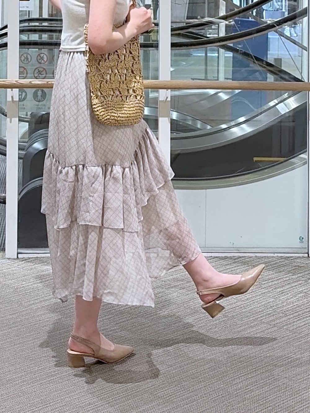 ホワイト系のスカート、ベージュ系のTシャツ/カットソー、ブラック系のパンプスを着用したレディースの夏コーディネートの3枚目の写真