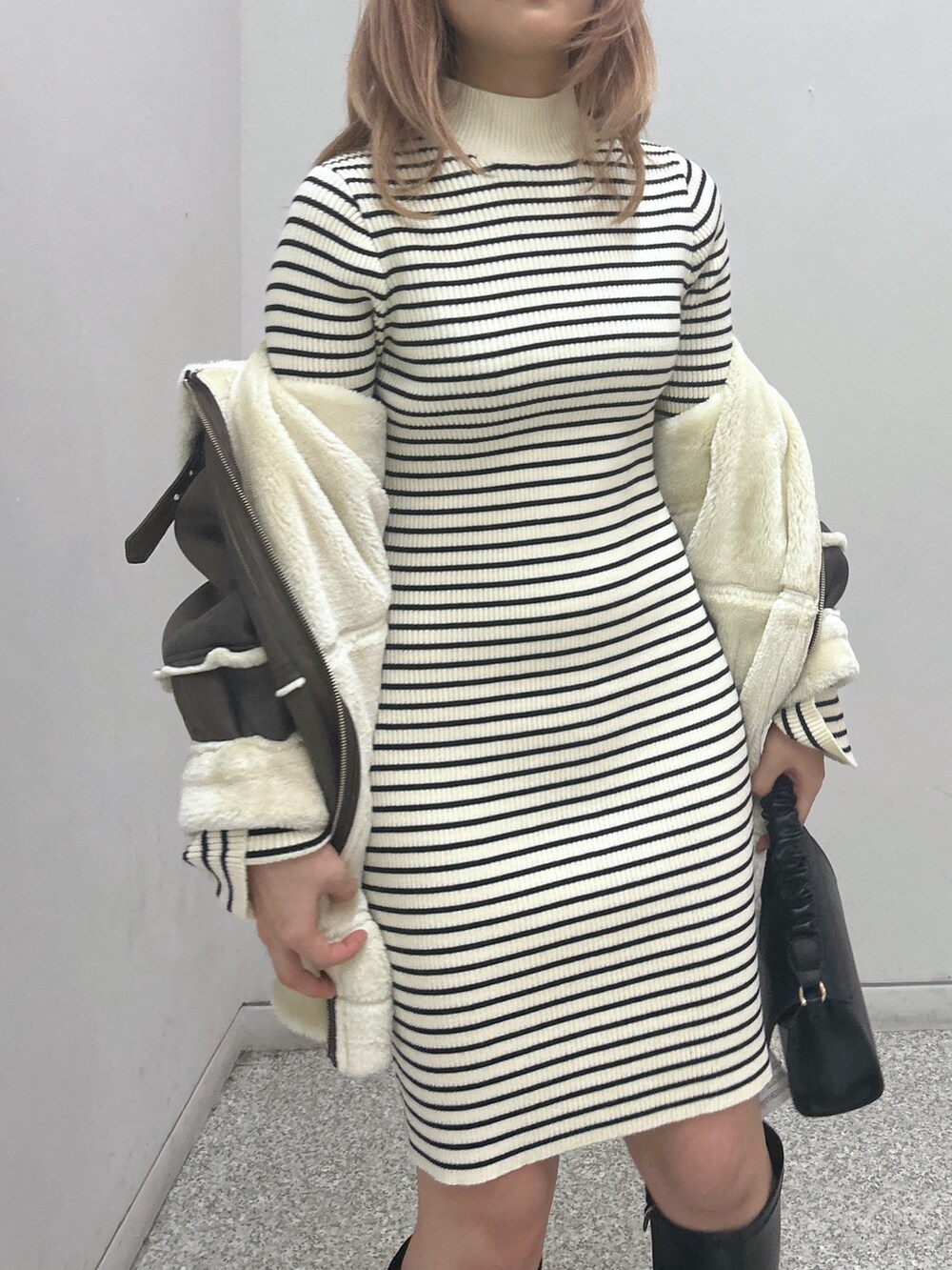 ブラウン系のブルゾン、ホワイト系のワンピース、ブラック系のショルダーバッグを着用したレディースの秋コーディネートの3枚目の写真