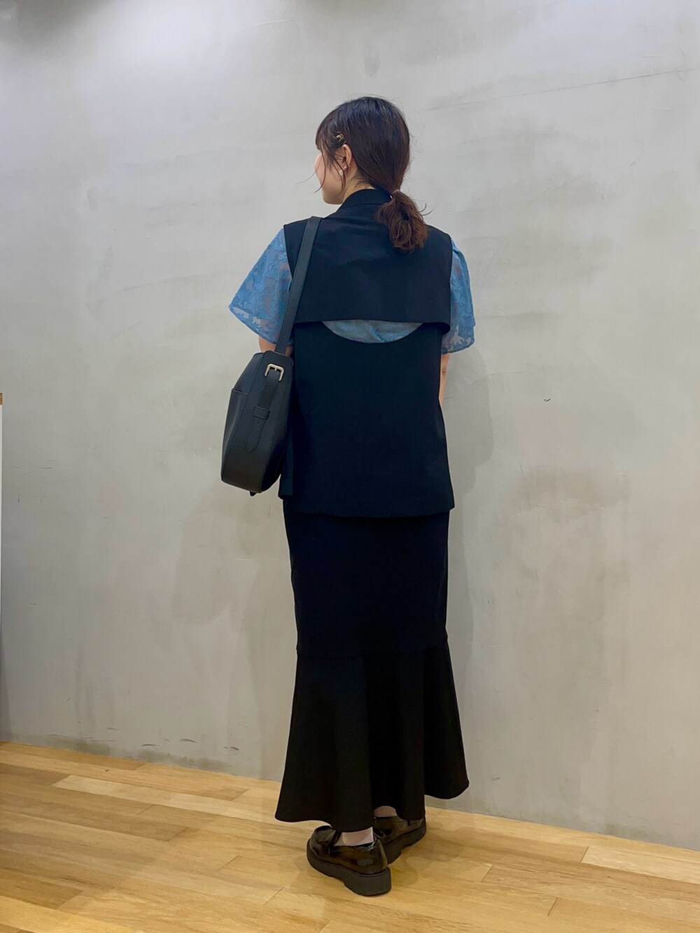 ブラック系のスカート、ブルー系のシャツ/ブラウス、ブラック系のショルダーバッグを着用したレディースの夏コーディネートの3枚目の写真