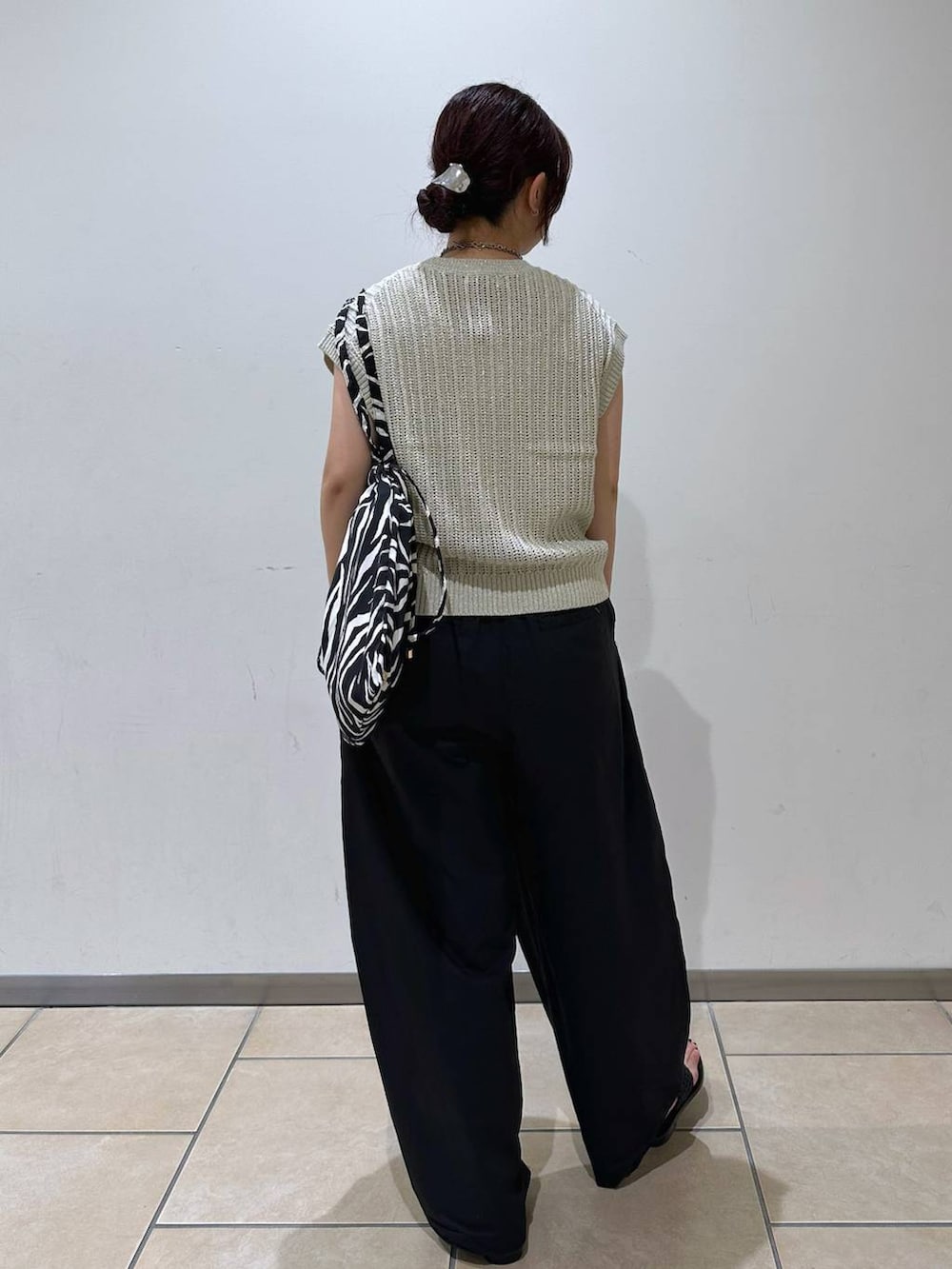 ブラック系のその他パンツ、ブラック系のサンダル、ベージュ系のニット/セーターを着用したレディースの夏コーディネートの3枚目の写真