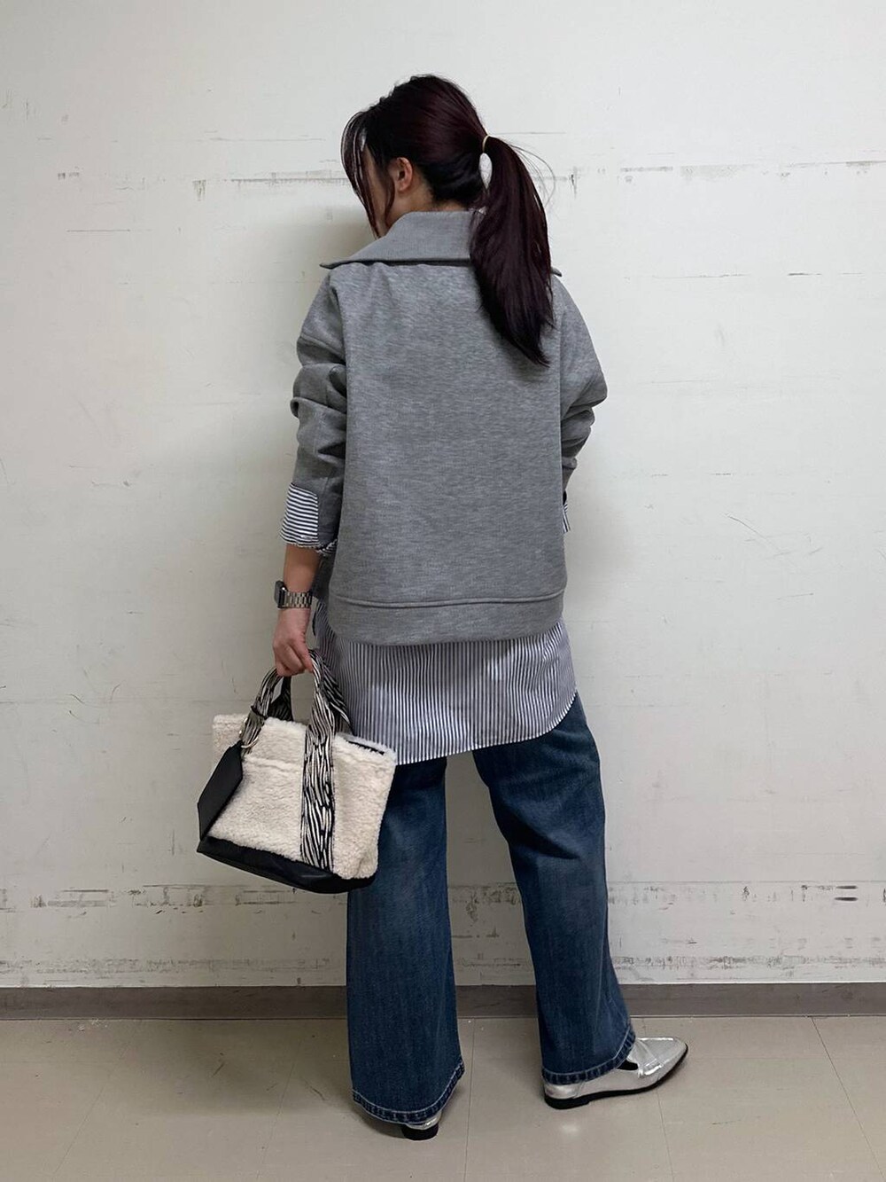 シルバー系のローファー、ブルー系のシャツ/ブラウス、ホワイト系のトートバッグを着用したレディースの冬コーディネートの3枚目の写真