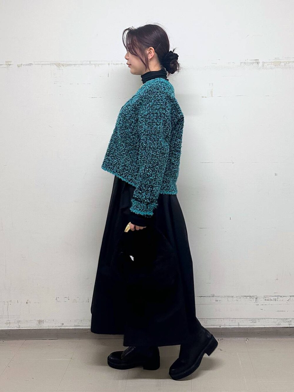 ブラック系のTシャツ/カットソー、ブラック系のトートバッグ、ブラック系のブーツを着用したレディースの冬コーディネートの2枚目の写真